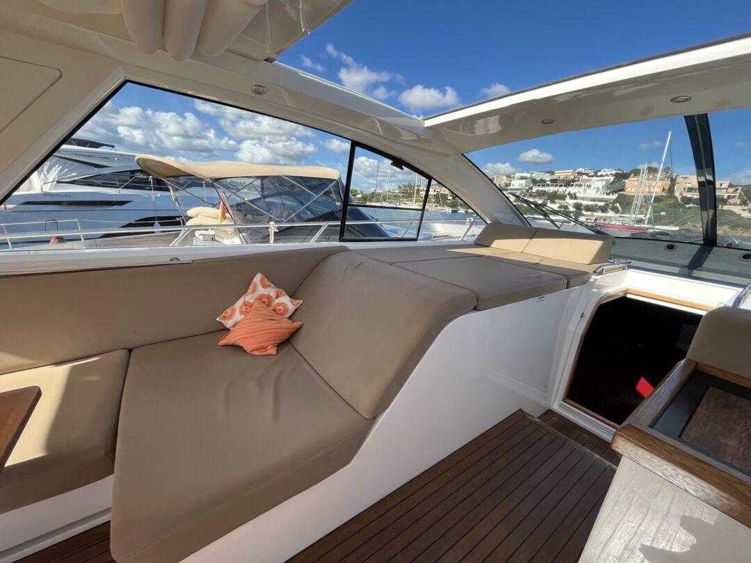 Luxurious 2012 Sealine SC 47 yacht interior with beige seating and decorative pillows.