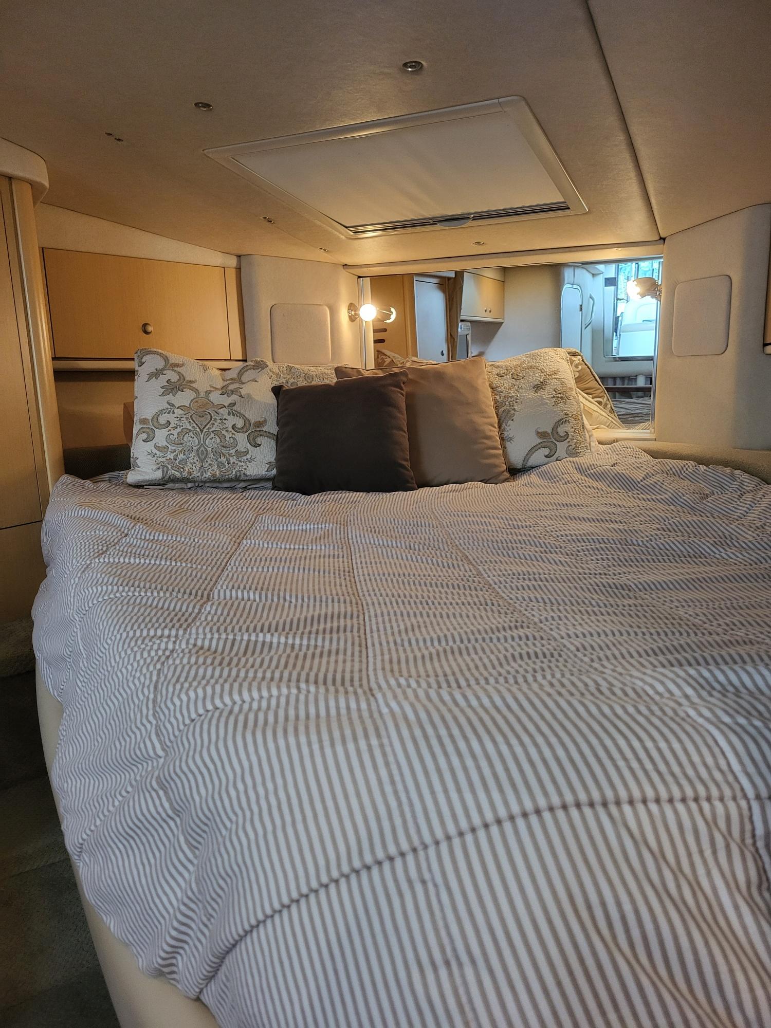 Cozy cabin interior of 2009 Sea Ray 310 Sundancer with comfortable bedding and ambient lighting.