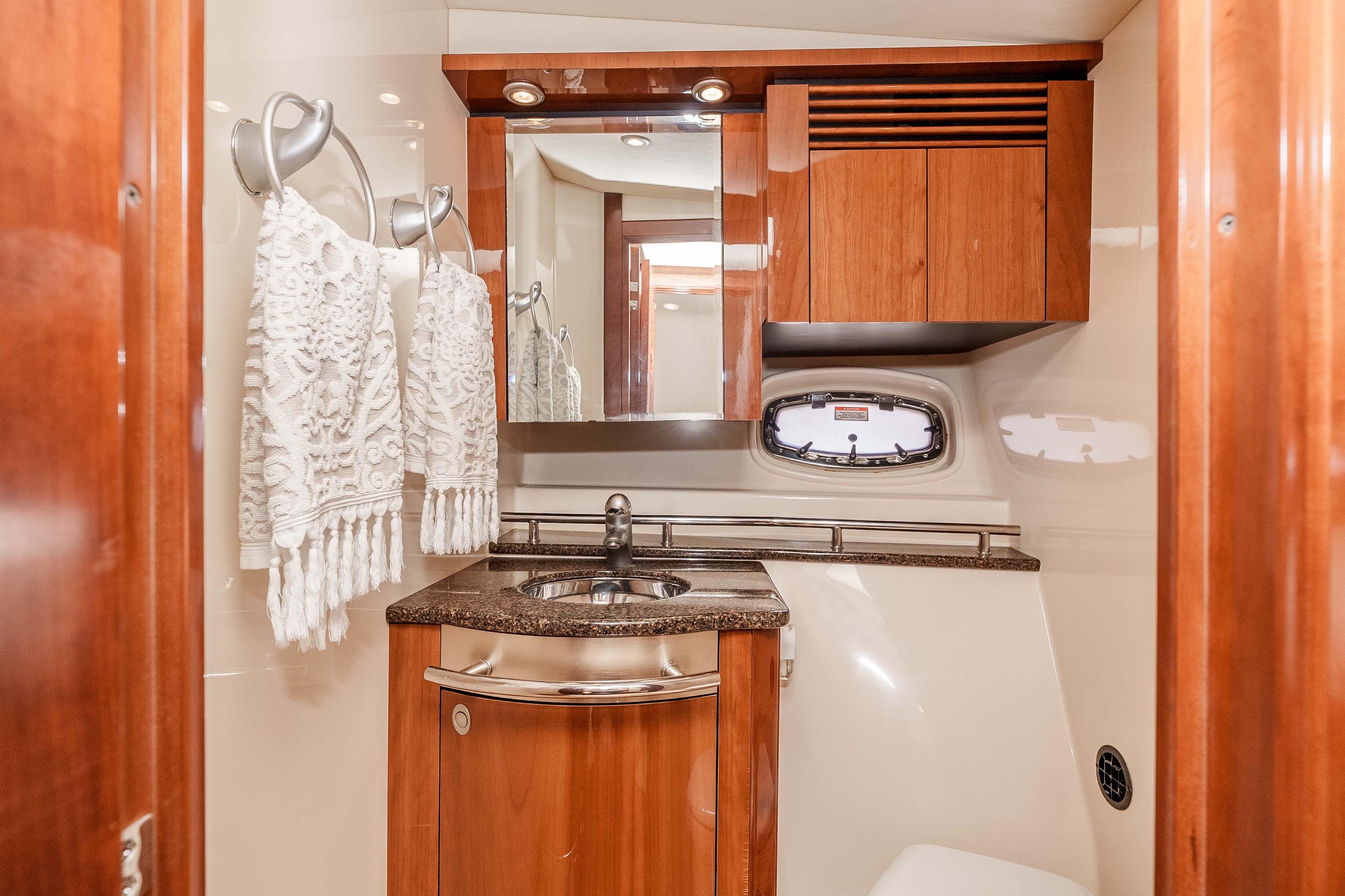 Luxurious 2007 Sea Ray 48 Sundancer yacht bathroom with wood cabinetry and elegant fixtures.