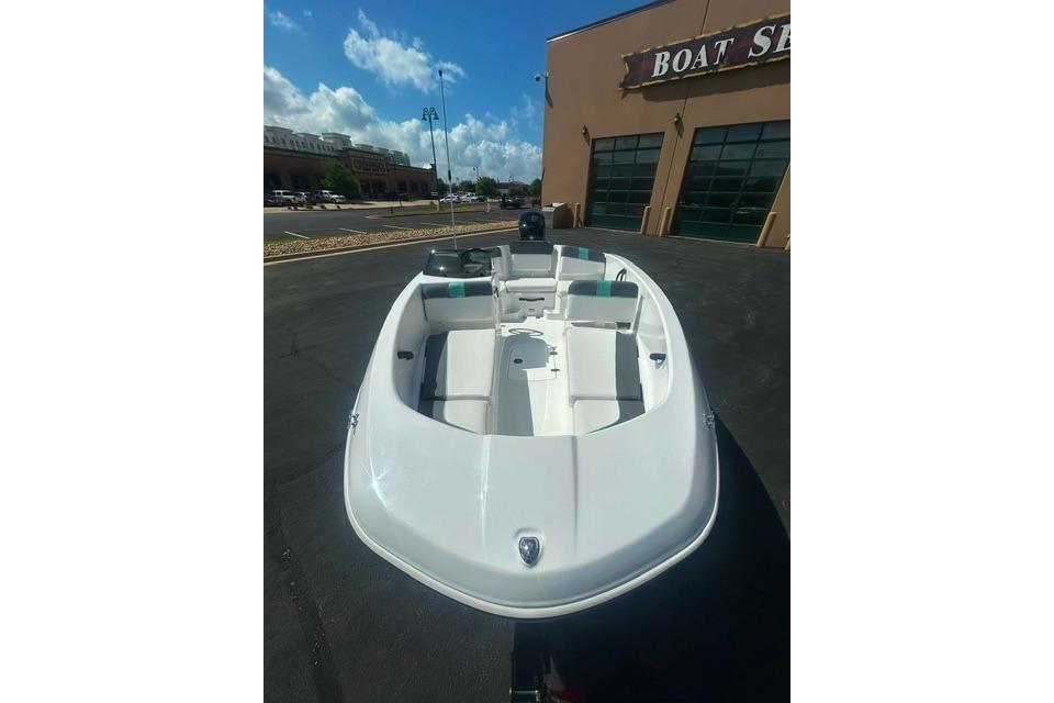 2026 Tahoe T16 boat displayed outside a showroom under a clear blue sky.
