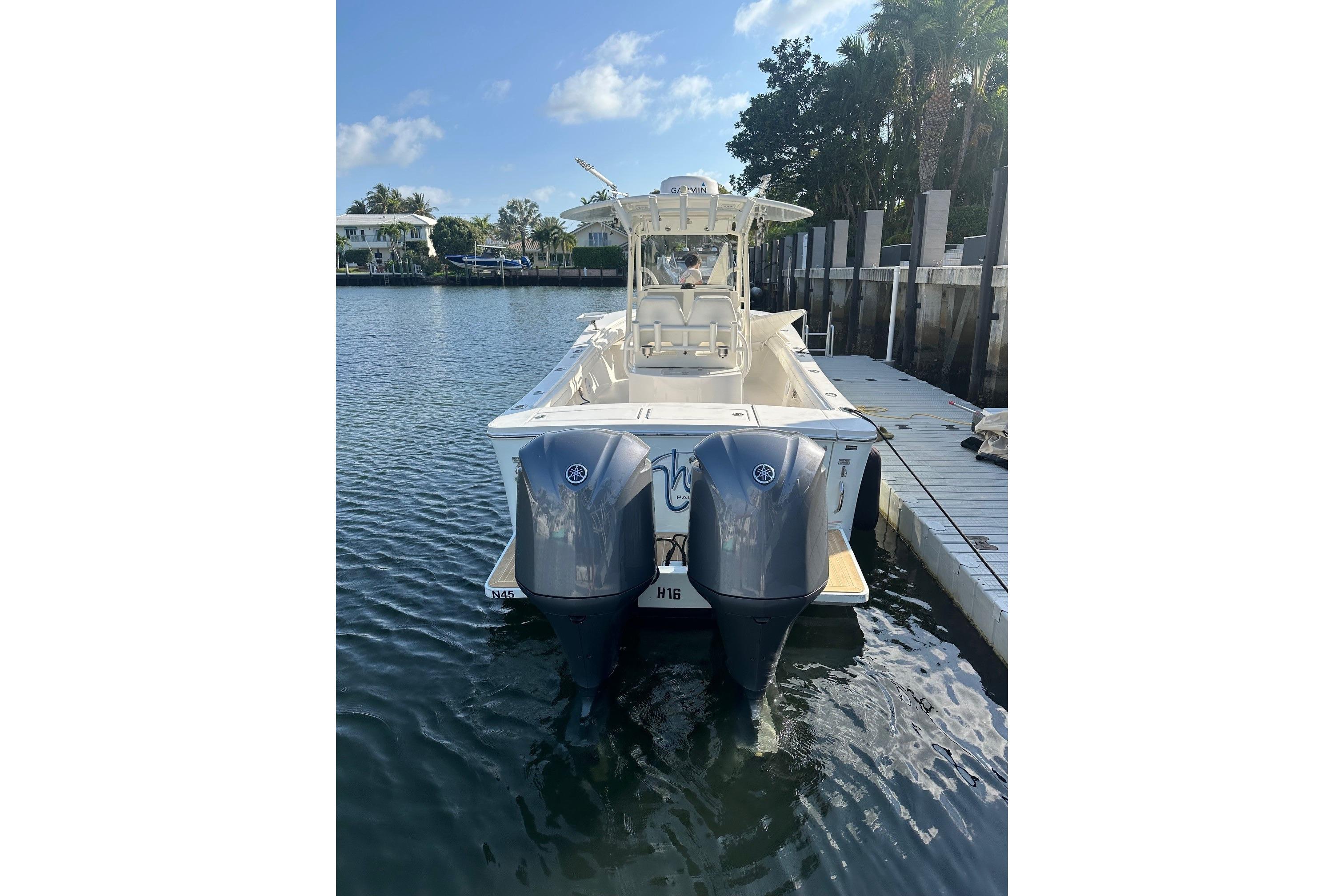 2017 Regulator 28 boat with dual outboard engines docked in a serene marina.