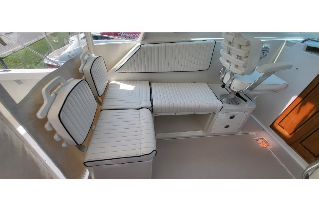 Interior seating of a 2006 Back Cove 29 boat, featuring white cushioned seats and a captain's chair.