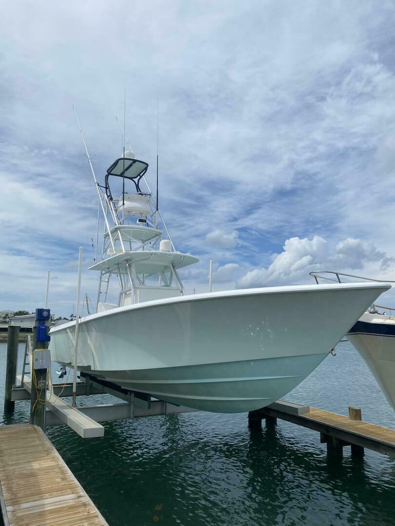 2012 Contender 39ST boat docked, featuring a sleek design under a cloudy sky.