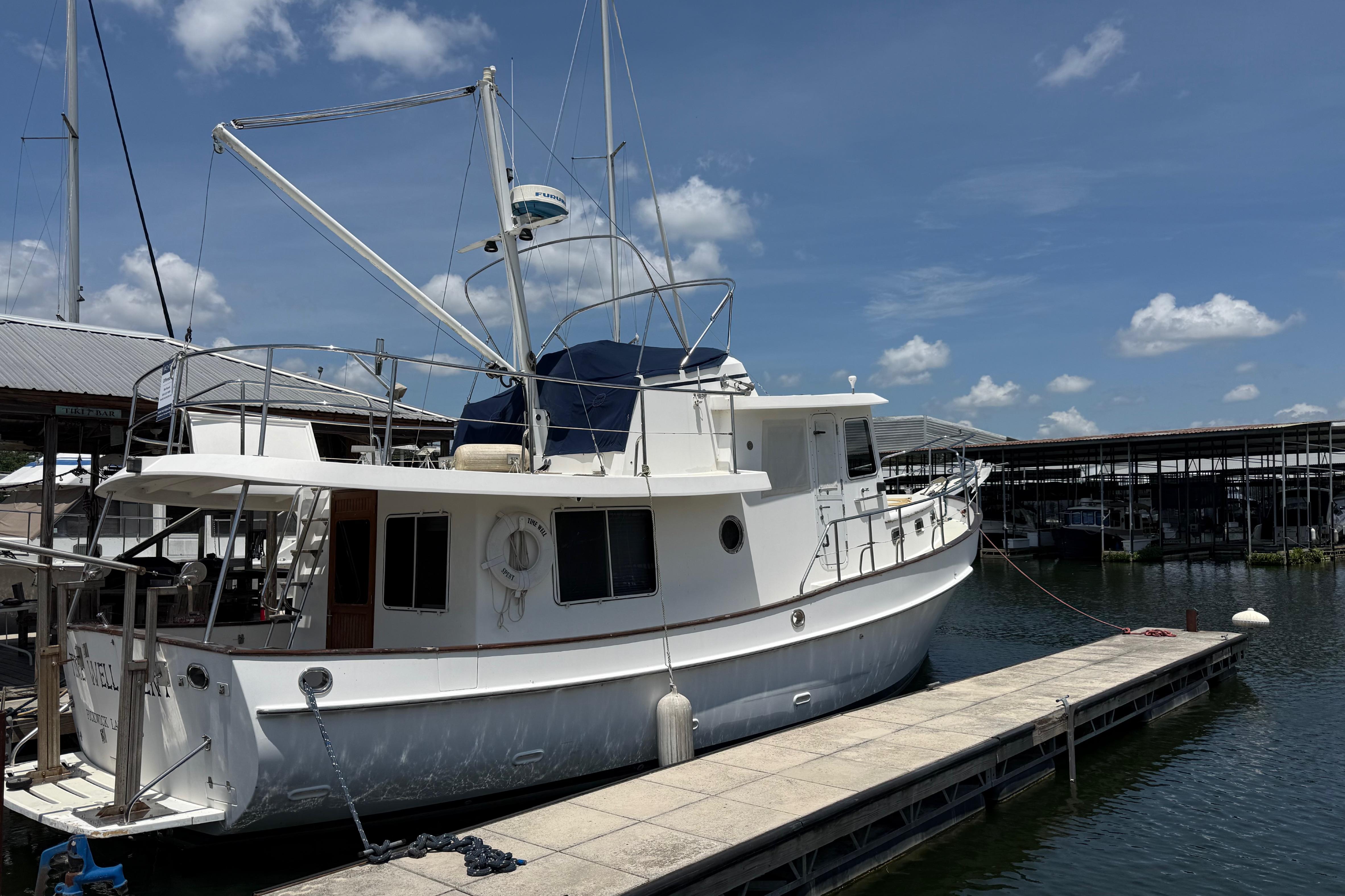 Kadey-Krogen 39 yacht from 2001 docked at a marina under a clear blue sky.