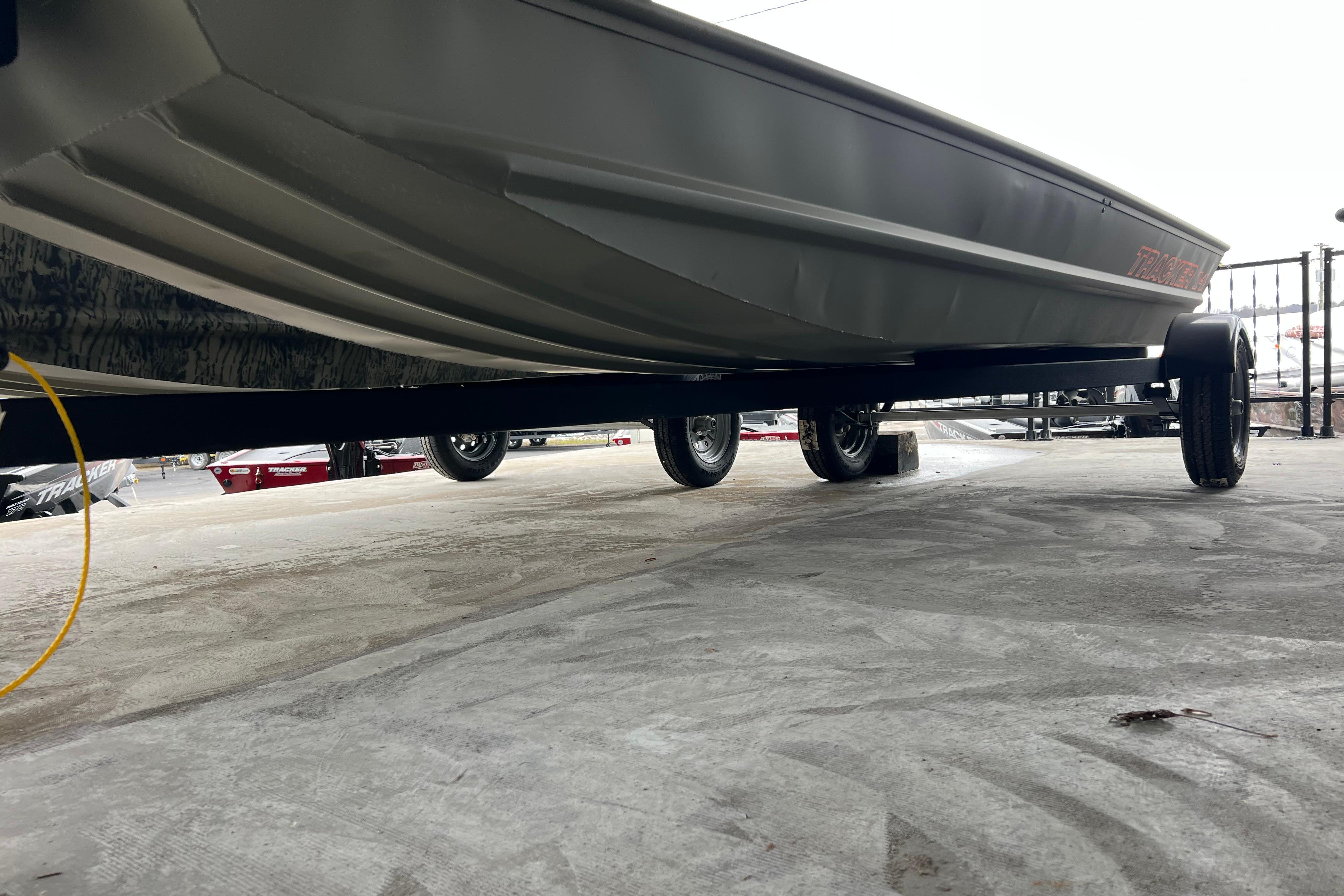 2026 Tracker Grizzly 14 Jon boat on trailer, viewed from below, showcasing hull design.