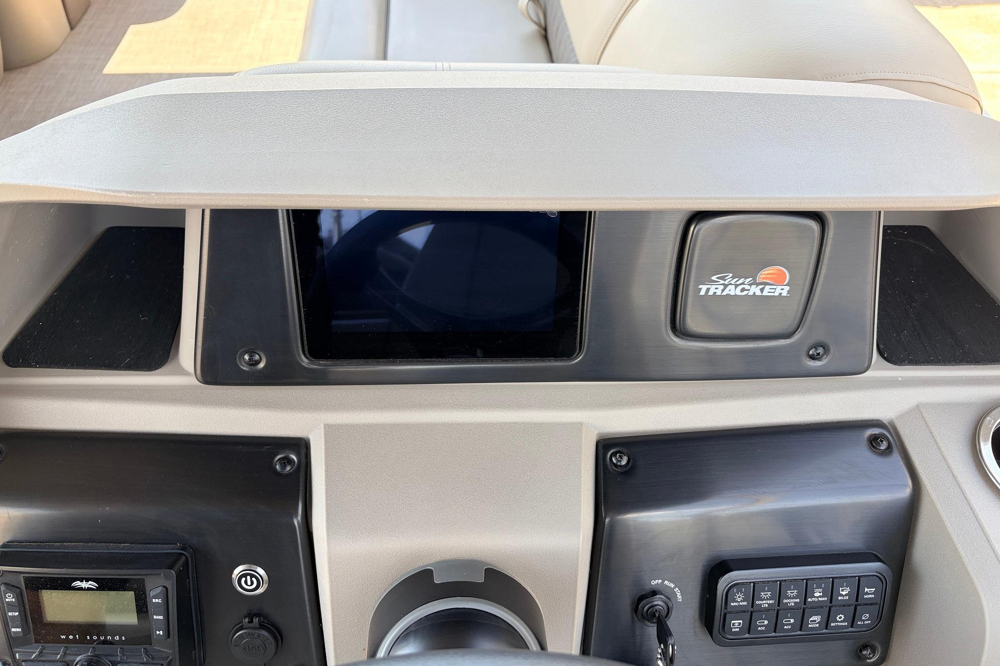2024 Sun Tracker SportFish 22 XP3 dashboard with controls and Sun Tracker logo.