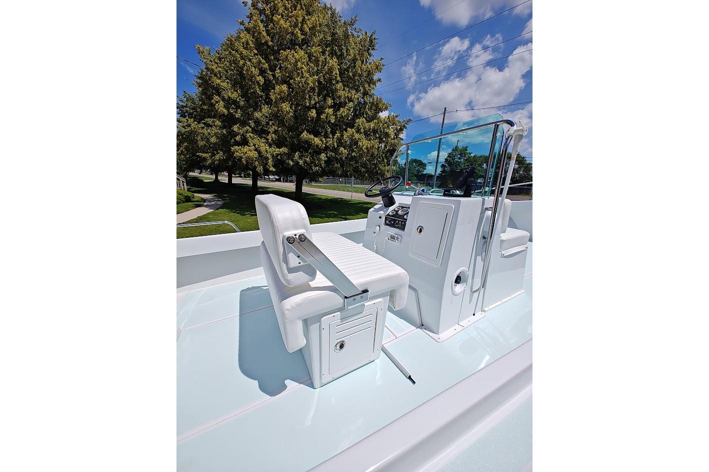 1975 Shamrock 200 Open boat interior with white seating and steering console.