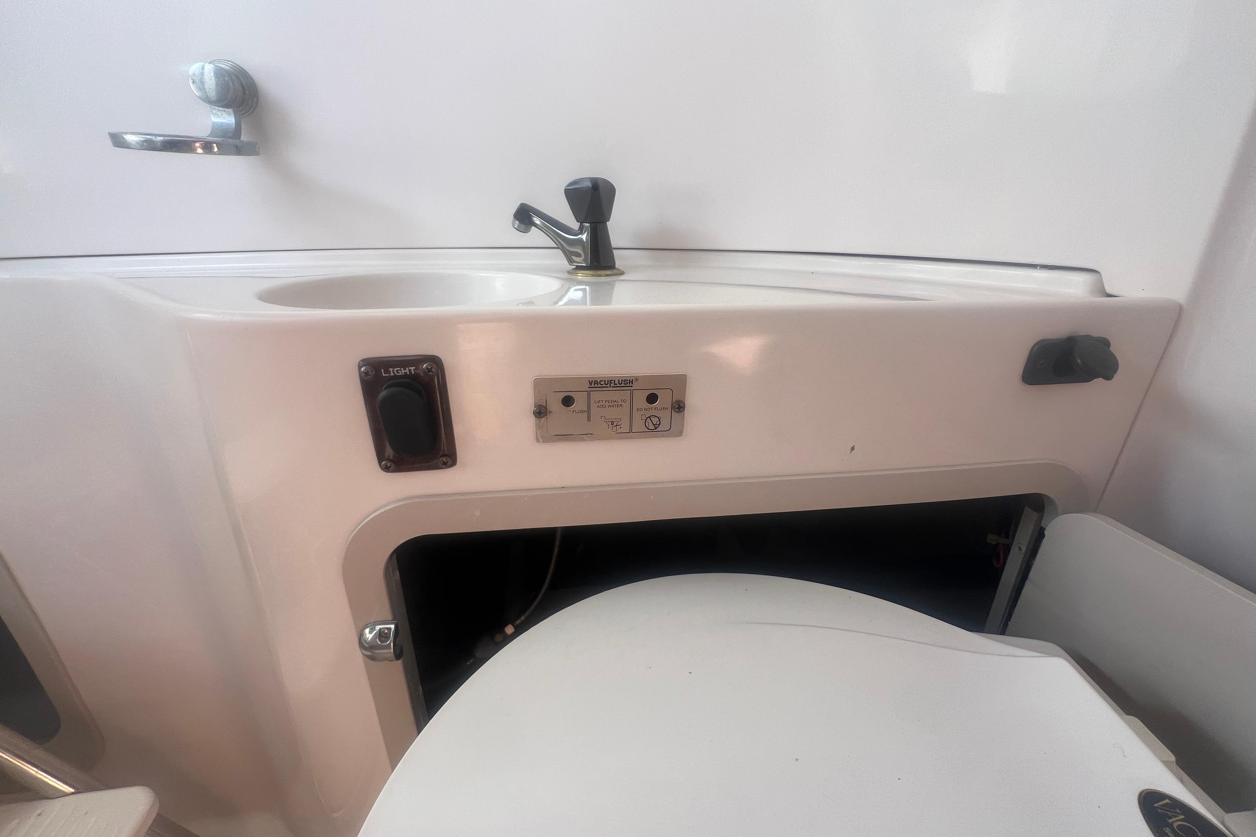 Interior of a 2002 Hurricane SunDeck 260 OB boat featuring a sink and storage area.