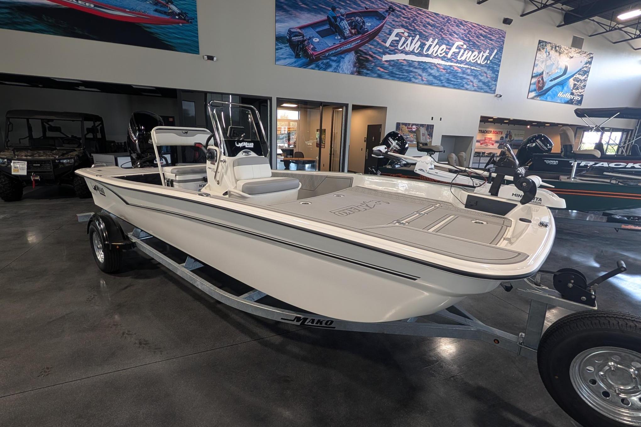 2026 Mako Pro Skiff 17 CC boat displayed in showroom with promotional banners.