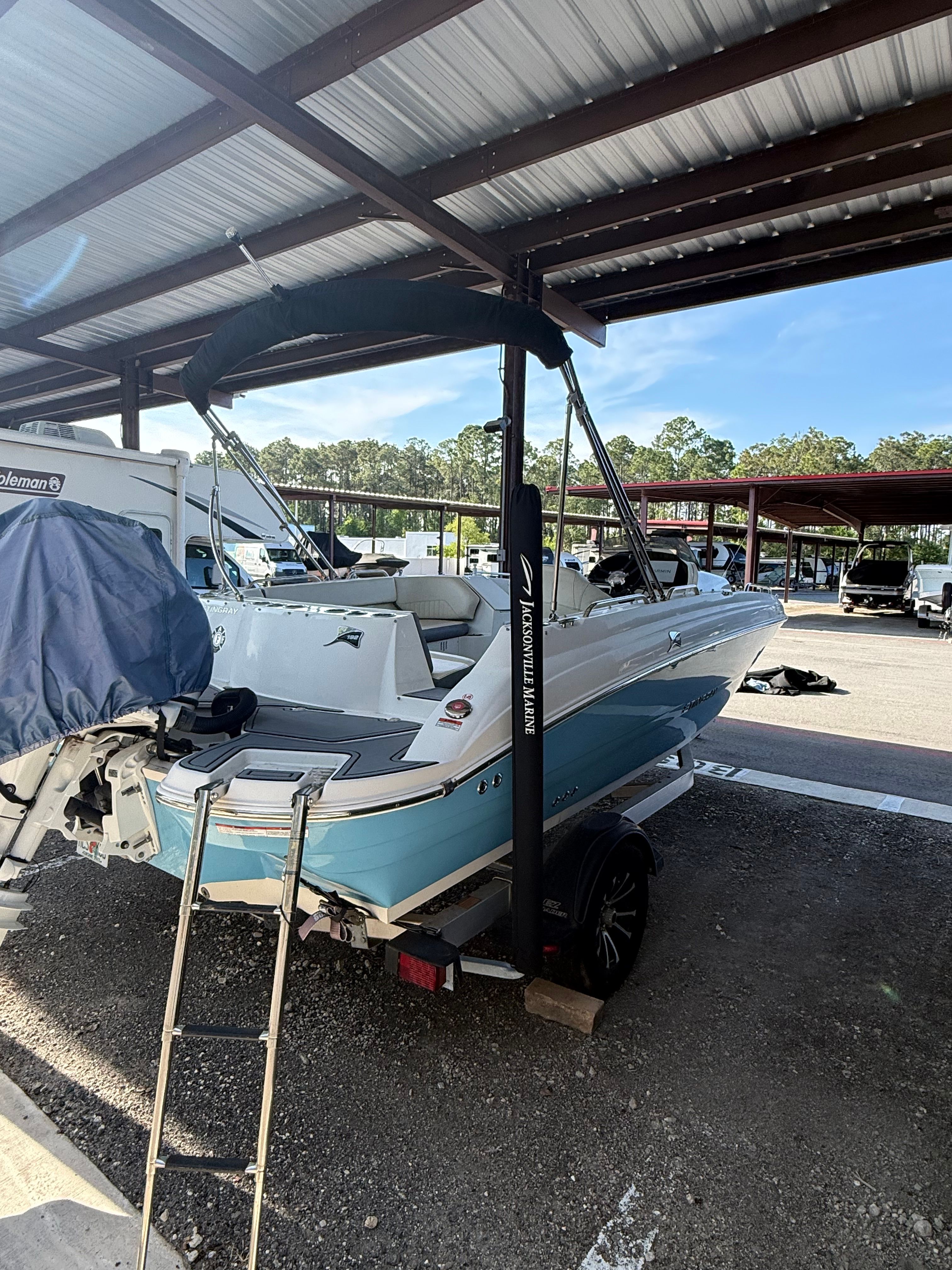2023 Stingray 192 SC boat under a covered area.