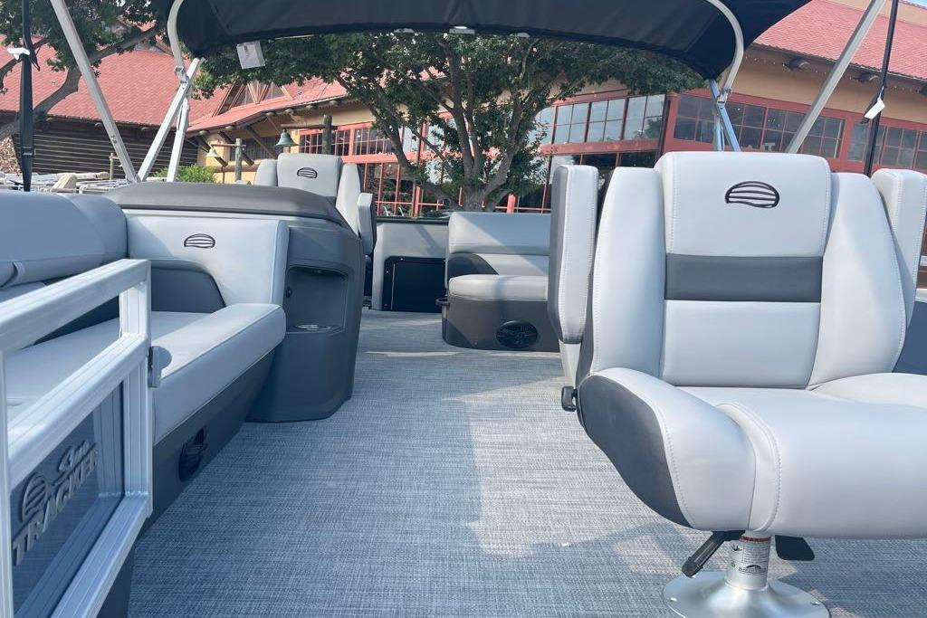 2026 Sun Tracker SportFish 20 DLX pontoon boat interior with gray seating and canopy.