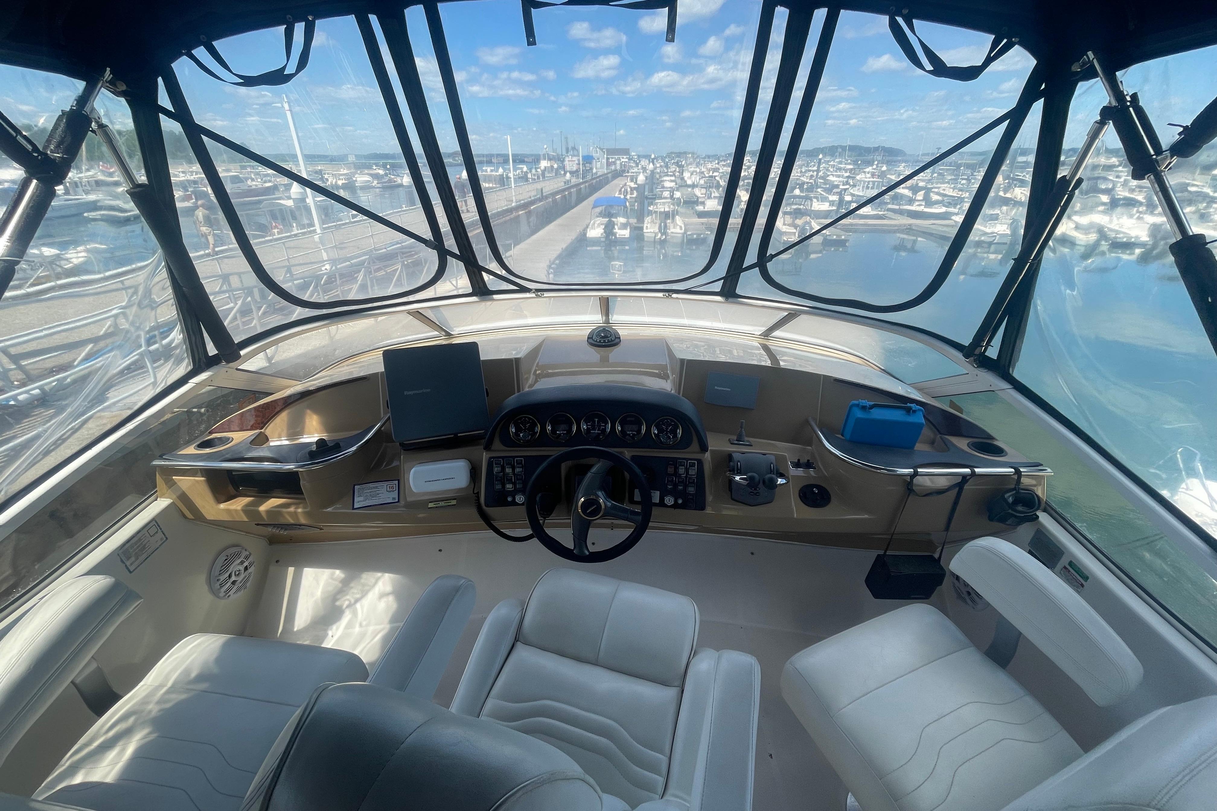 Interior view of 2002 Carver 410 Sport Sedan yacht cockpit with marina backdrop.
