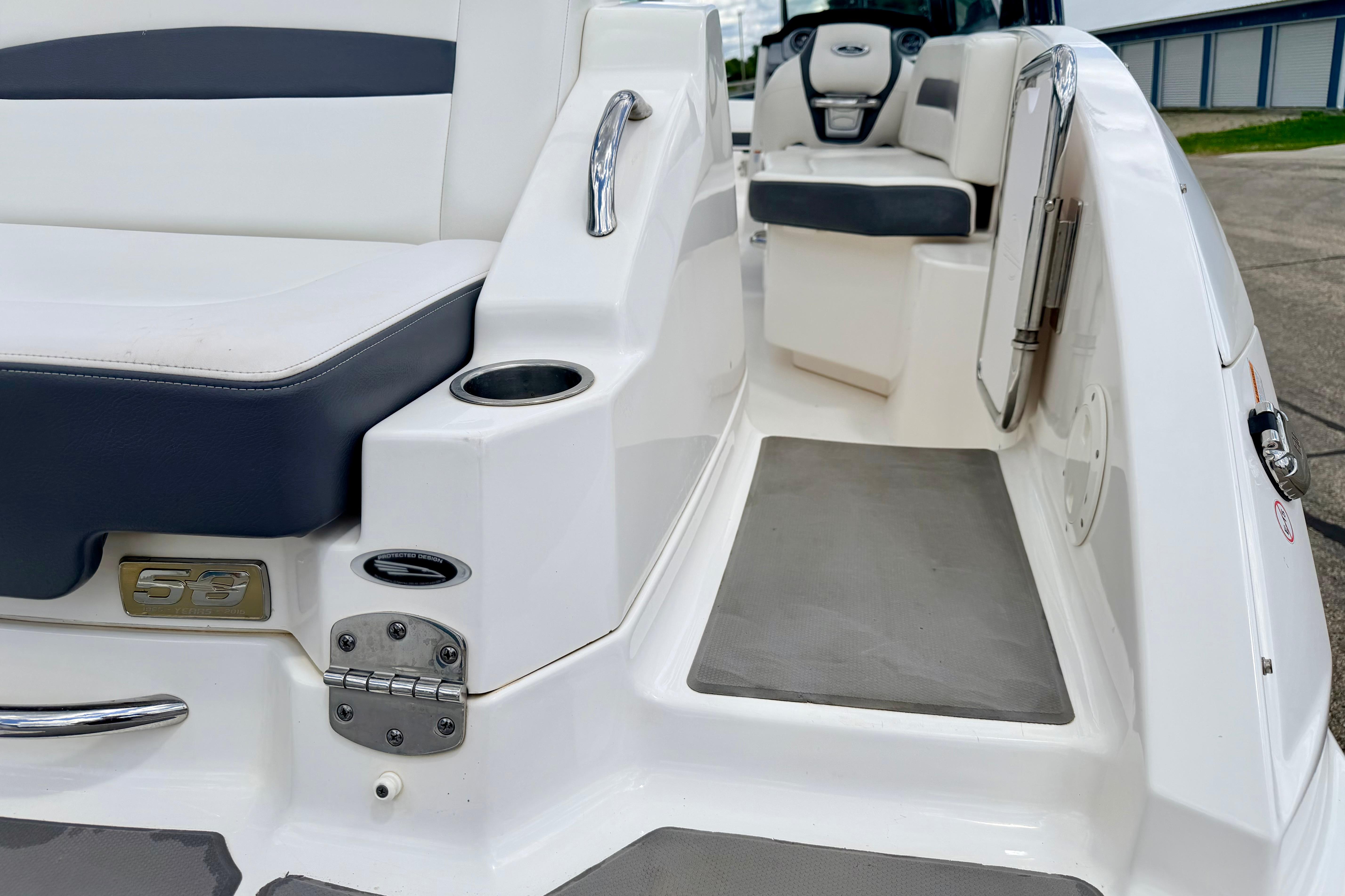 2015 Chaparral Sunesta 264 boat interior, featuring seating and cup holder on a sleek deck.
