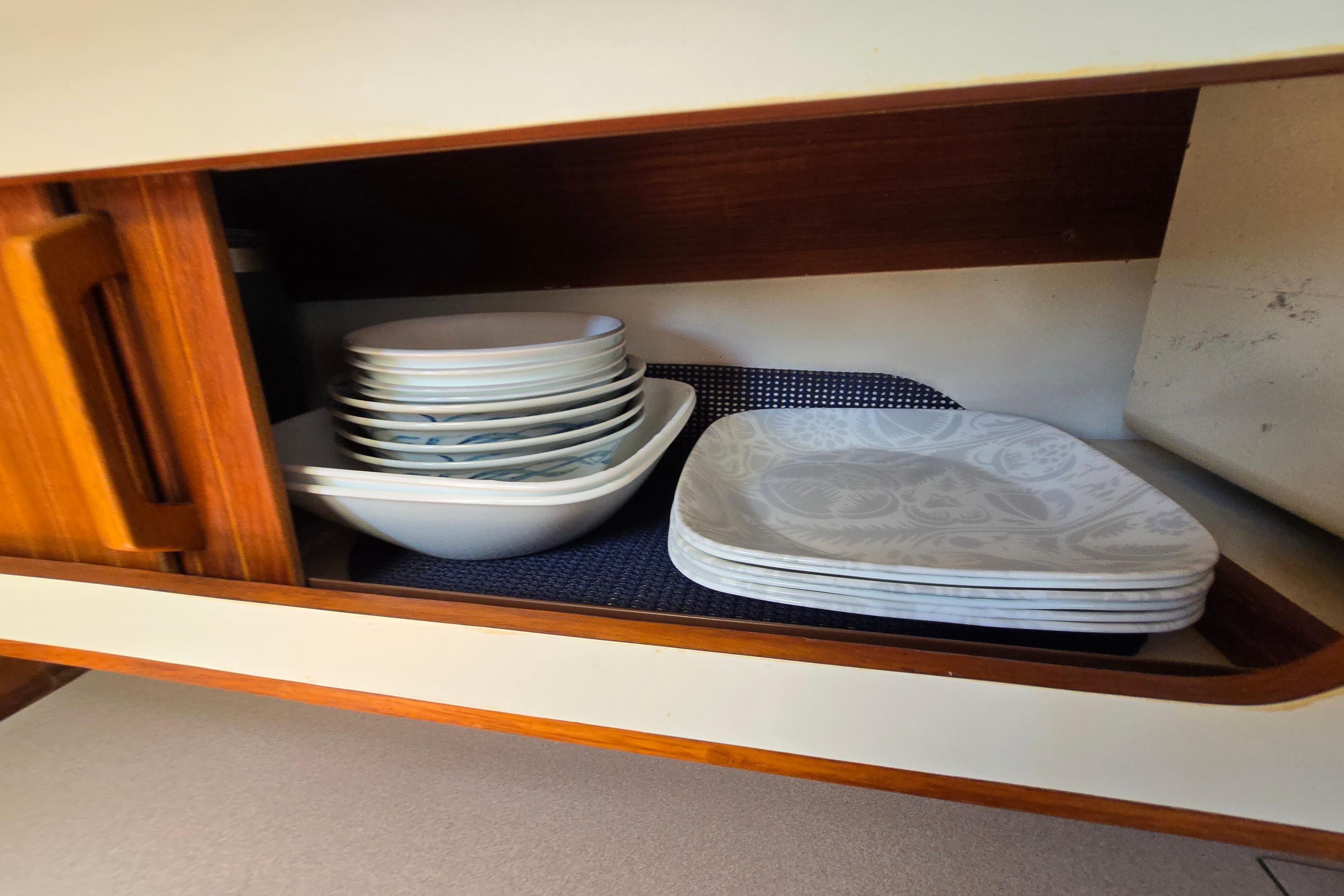 Cabinet with stacked plates and bowls inside a 1993 Caliber 35 model.