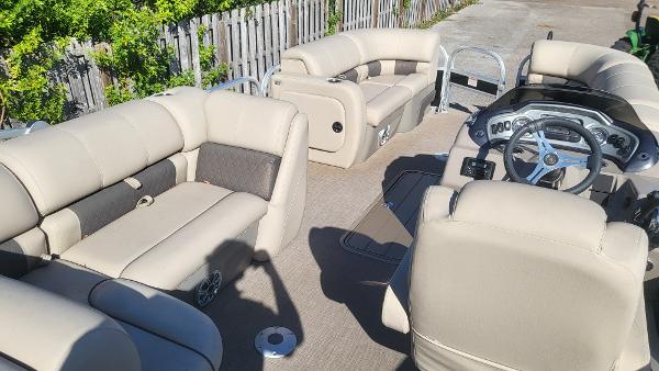 2023 Sun Tracker SportFish 22 XP3 pontoon boat interior with beige seating and steering console.
