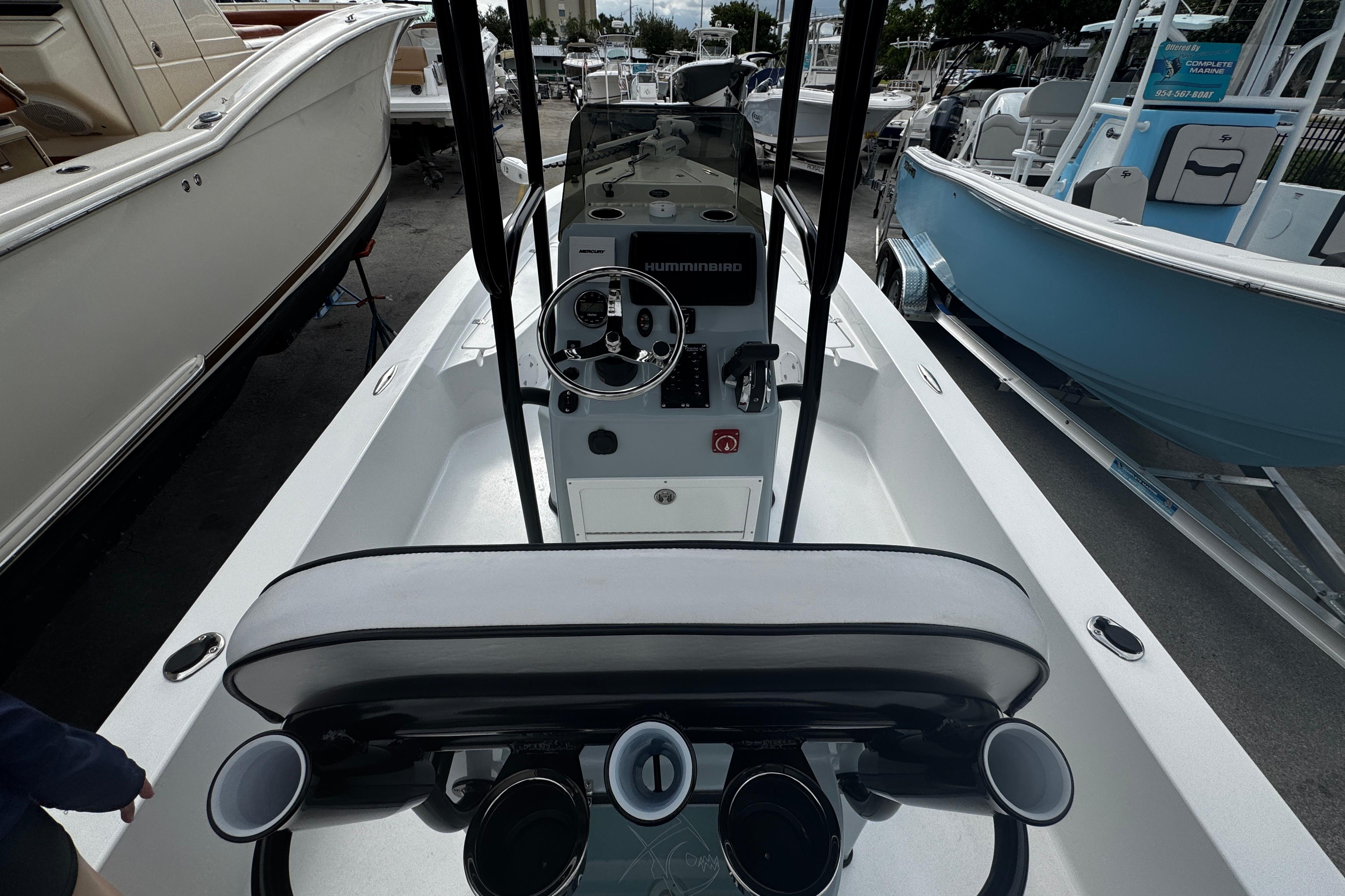 2026 Piranha Casador B2200 boat interior with steering console and seating, docked among other boats.