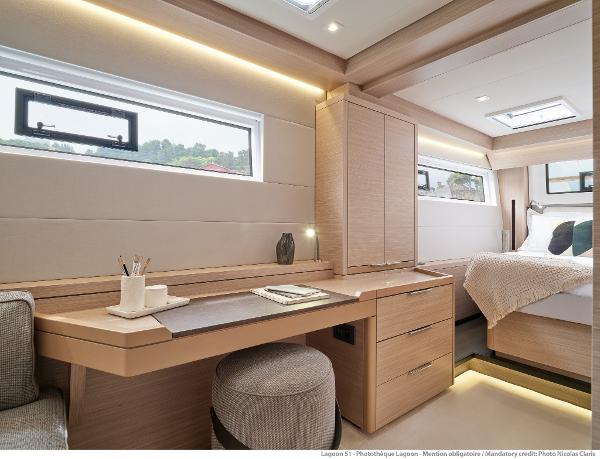 Luxurious interior of 2025 Lagoon 51 ICONIC yacht with modern desk and cozy bedroom.