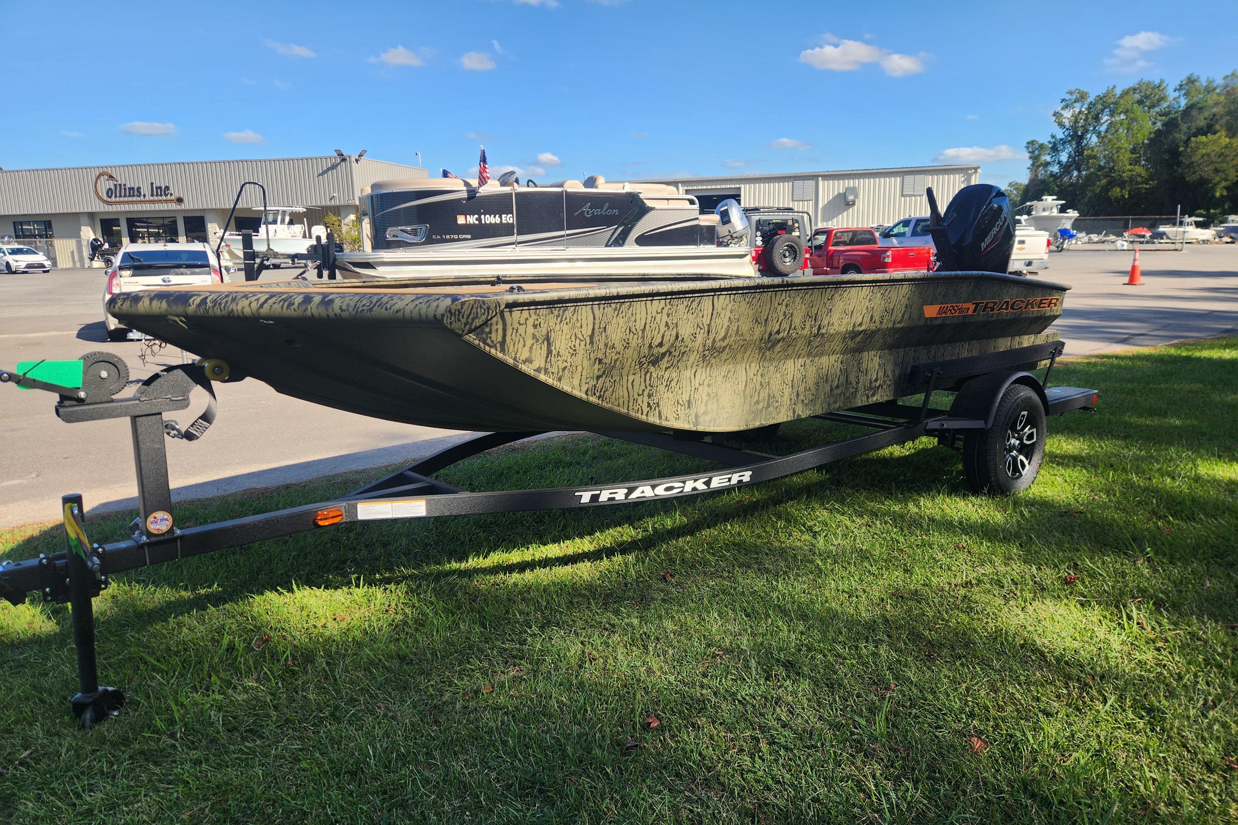2026 Tracker Grizzly 1756 T Marsh boat on trailer, parked on grass.
