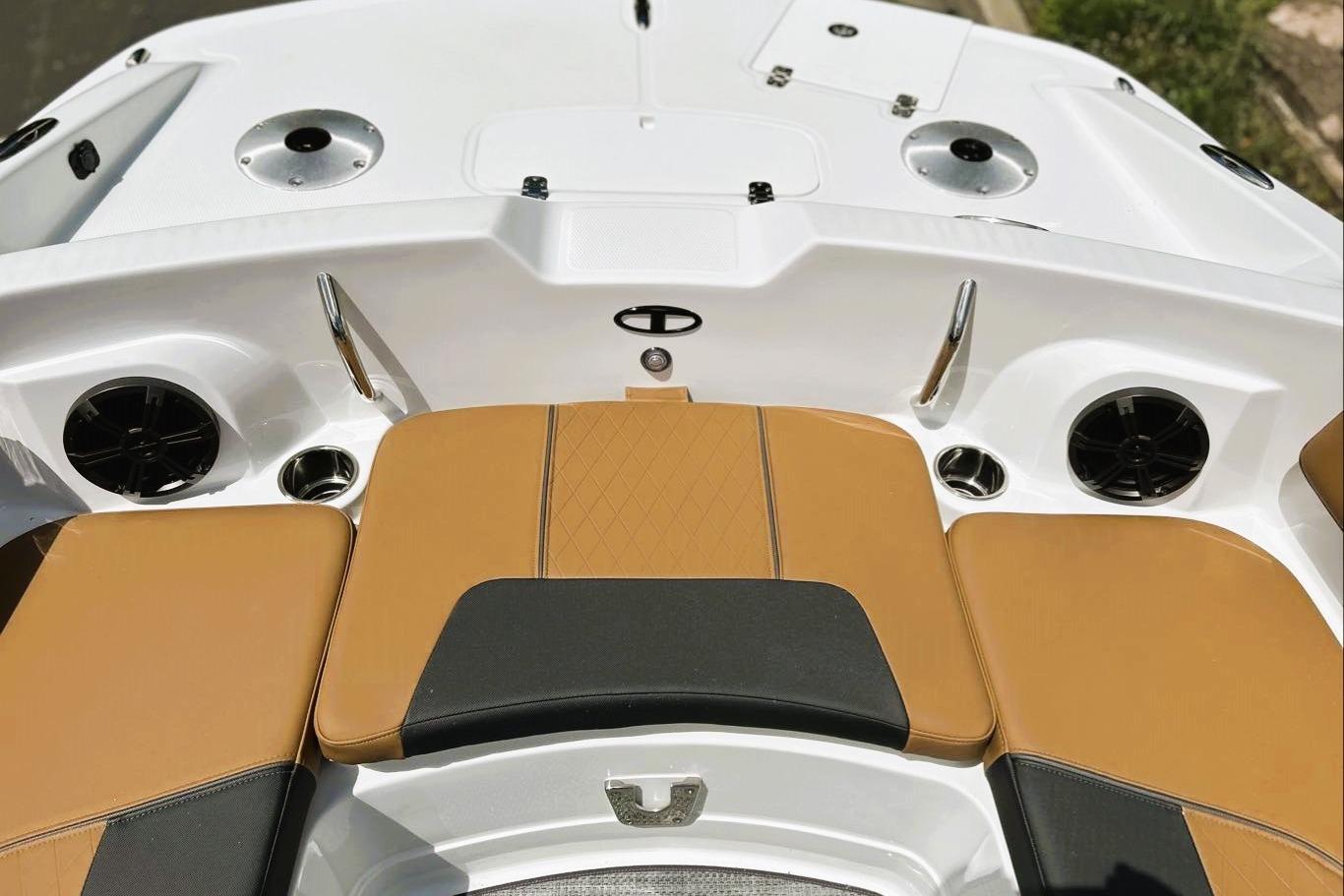 2026 Tahoe 2150 boat interior with tan and black seating, cup holders, and speakers.