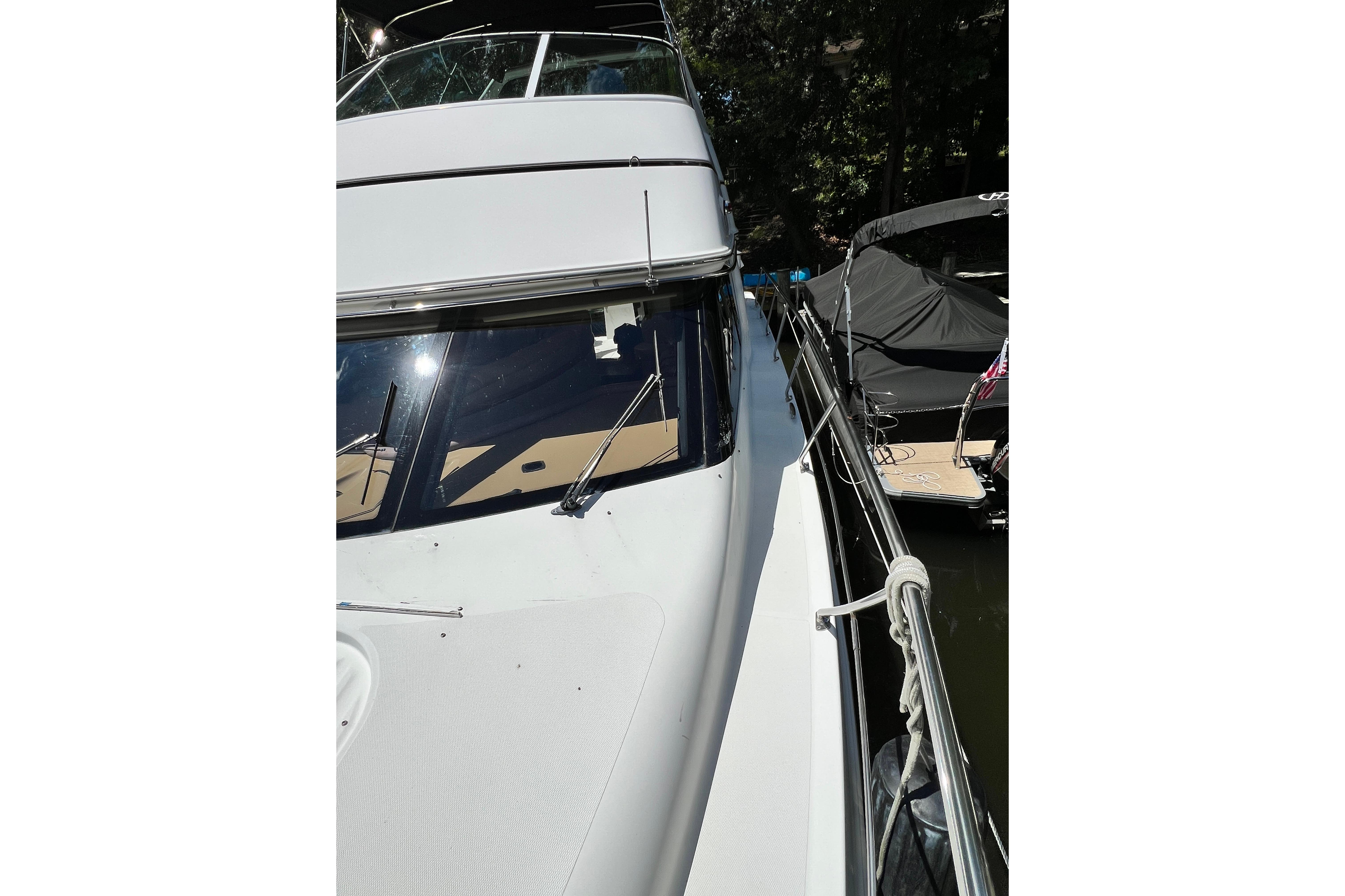 2003 Carver 450 Voyager Pilothouse yacht docked, side view with railing and windows.