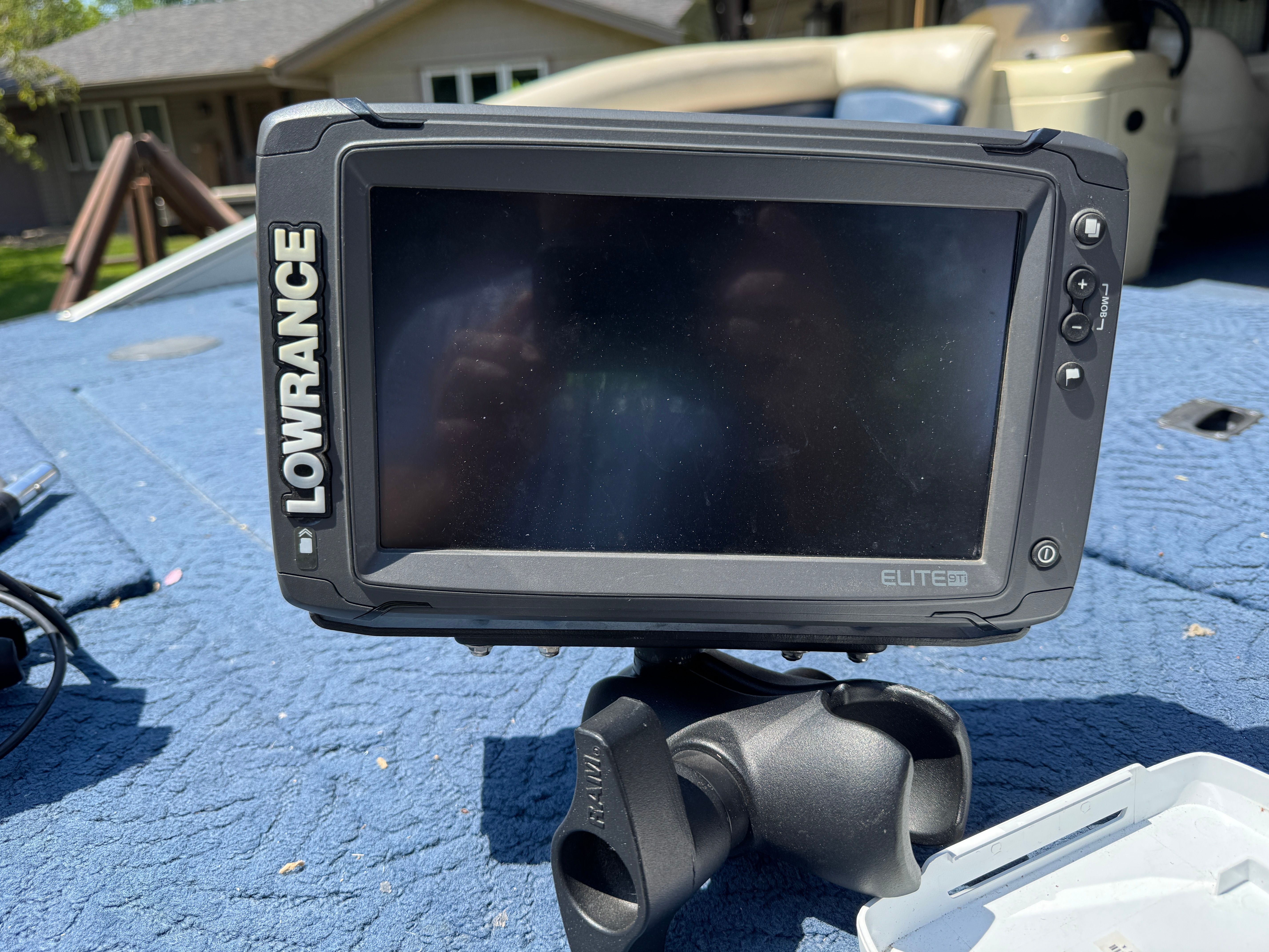 A Lowrance Elite screen on a boat with a blue cover.