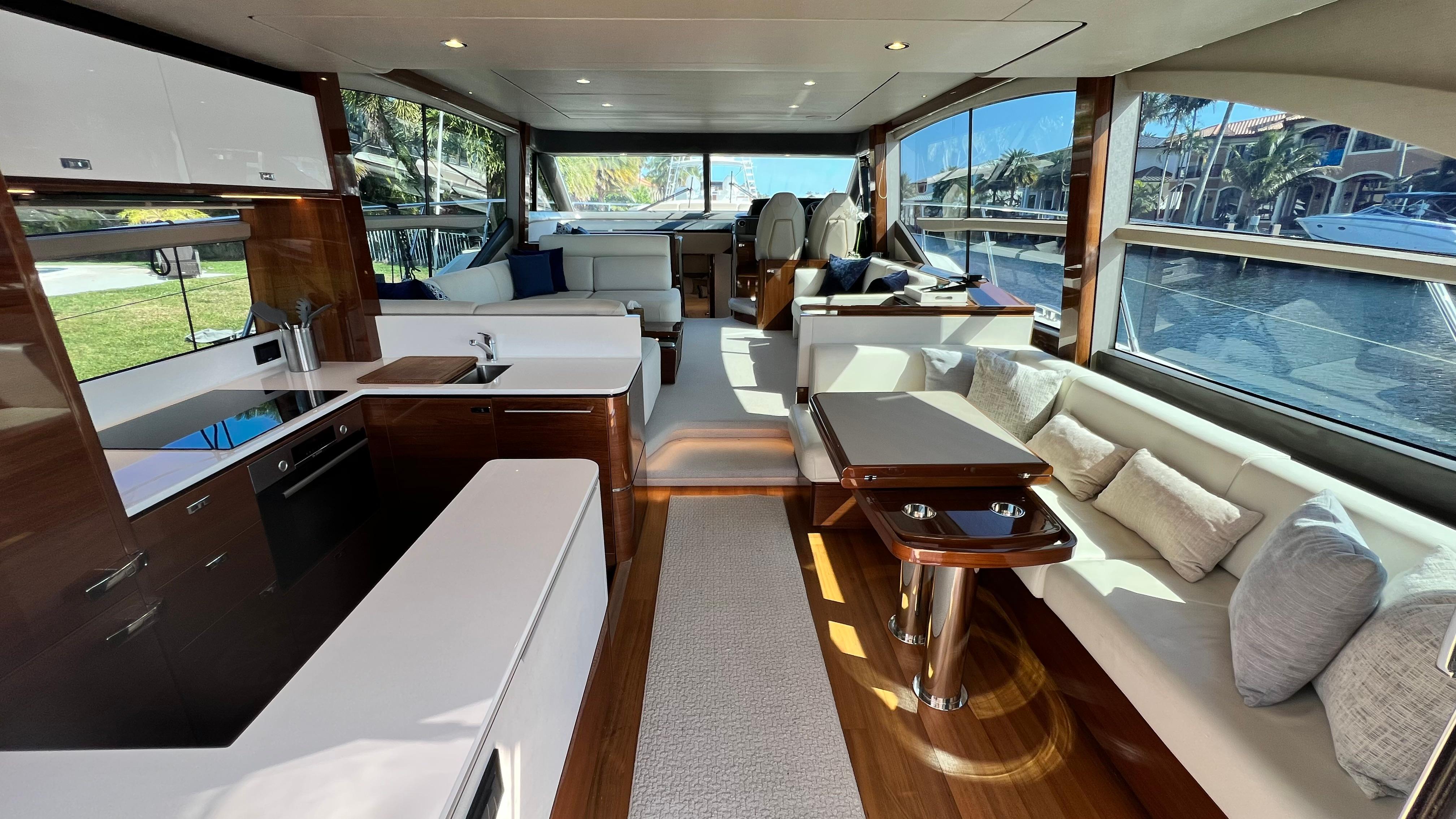 Luxurious interior of a 2019 Princess F62 yacht with modern furnishings and large windows.