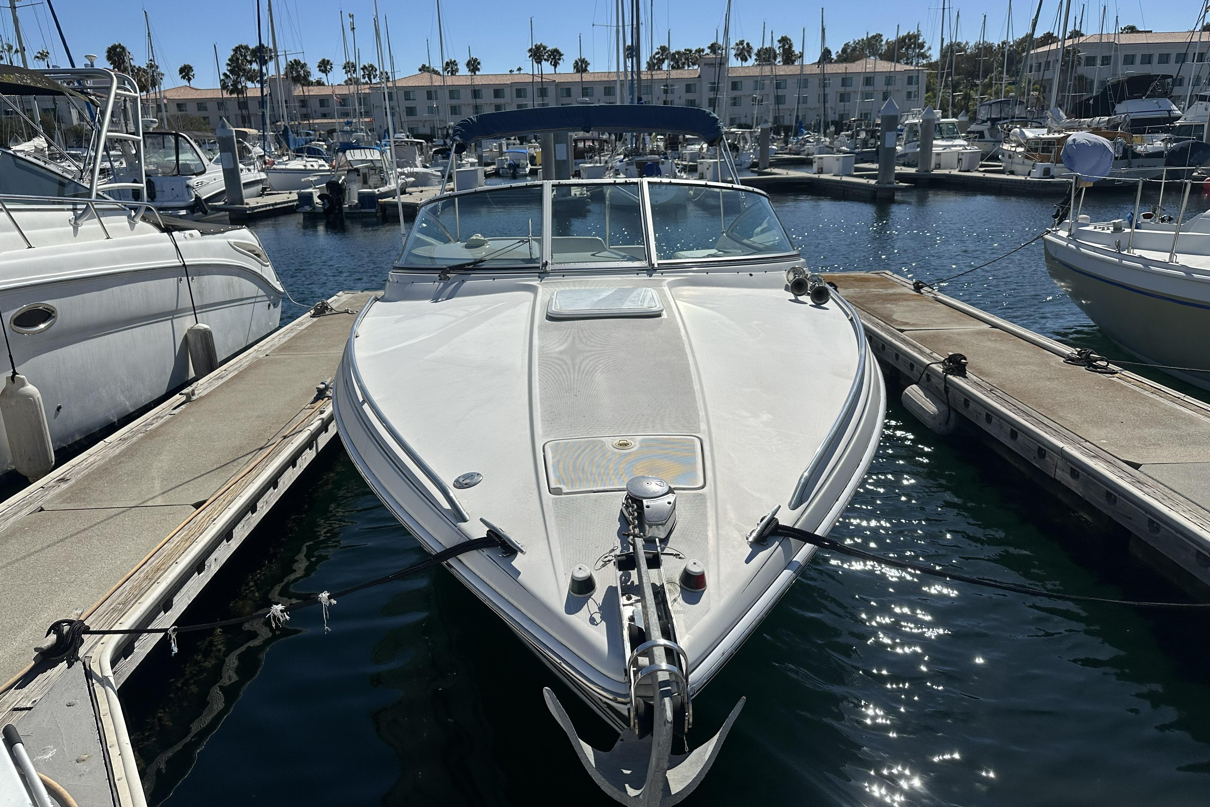 2000 Formula 280 Sun Sport boat docked in a marina under clear skies.