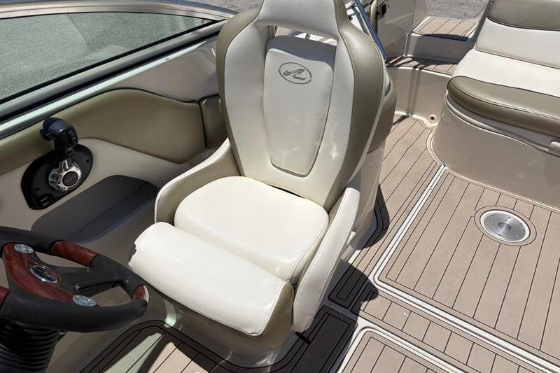 Captain's seat and helm of 2007 Sea Ray 240 Sundeck boat, featuring beige upholstery.