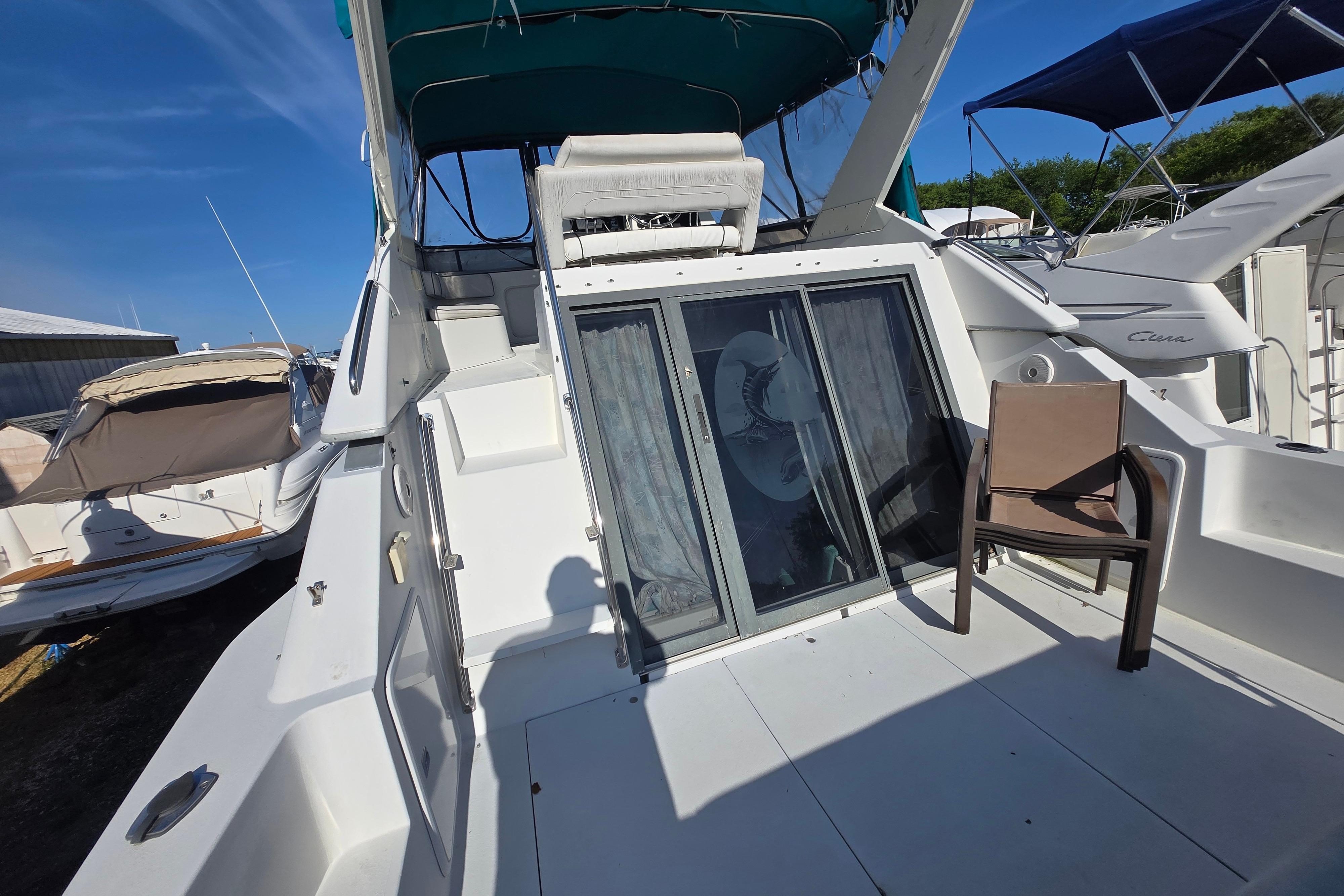 1994 Carver 380 Santego yacht deck with seating and sliding glass doors.