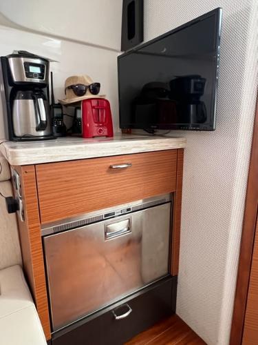 2019 Pursuit S 408 Sport interior with coffee maker, TV, and wooden cabinetry.