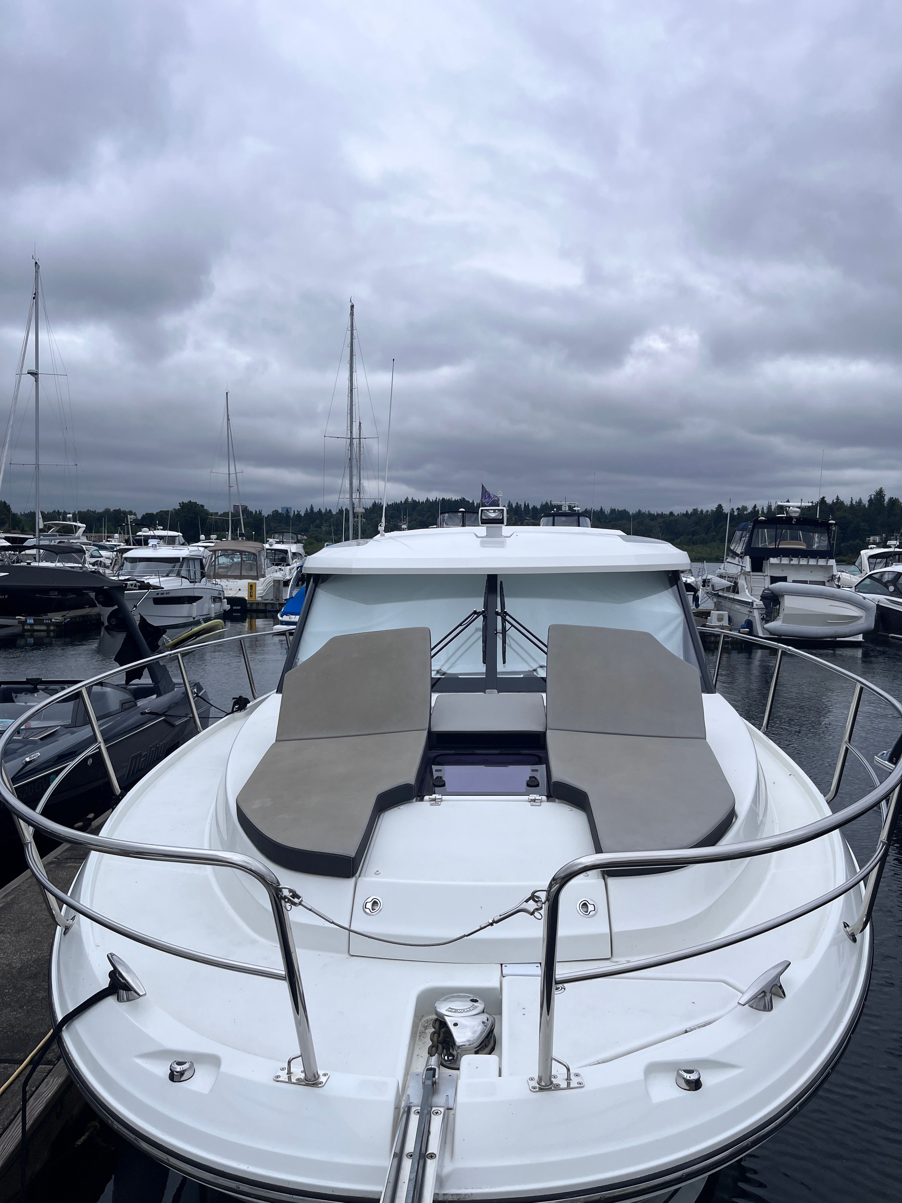 A 2021 Jeanneau NC 1095 is docked. It features a spacious foredeck.