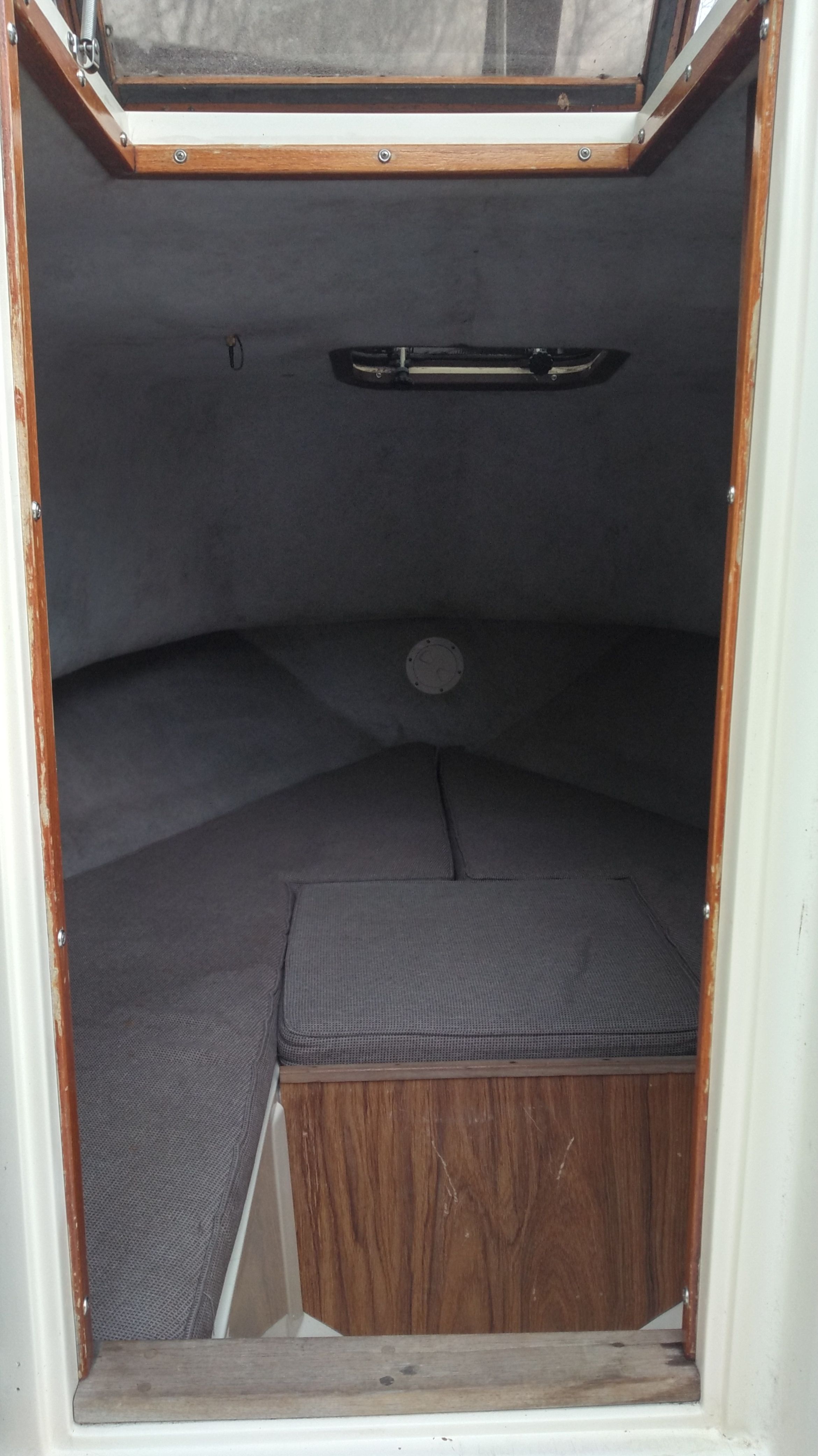 Interior of a 1989 Mako 240 Walk Around with gray cushions.
