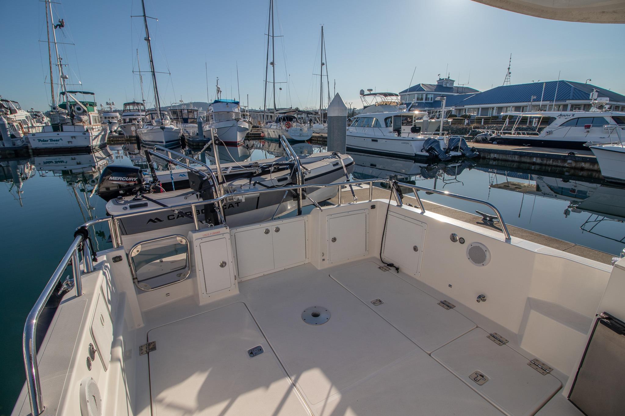 Open deck of a 2016 Aspen C100 boat docked at a marina.