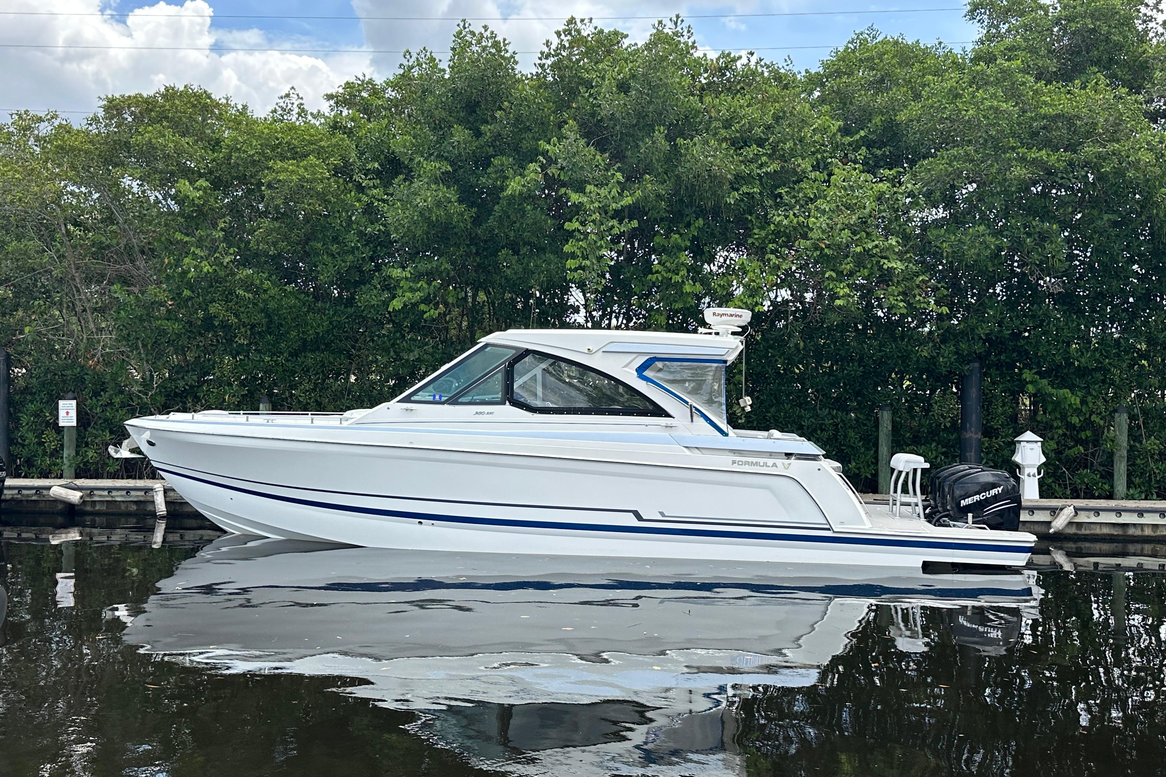 2021 Formula 380 Super Sport Crossover OB boat docked on calm water.