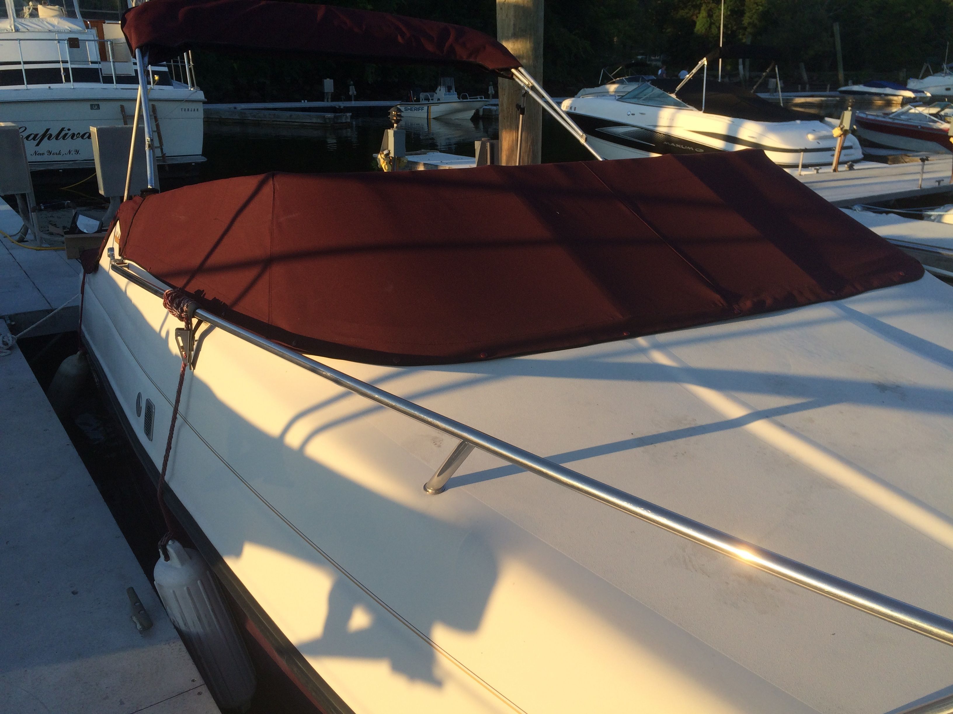 A 1992 Crownline Cudy Cruser docked, featuring a maroon cover.
