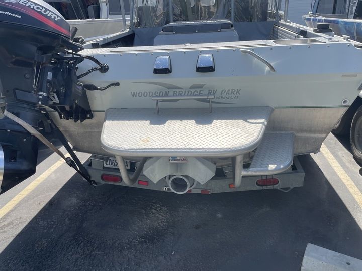 A 22-foot open bow jet boat from 2004 is parked in a lot.