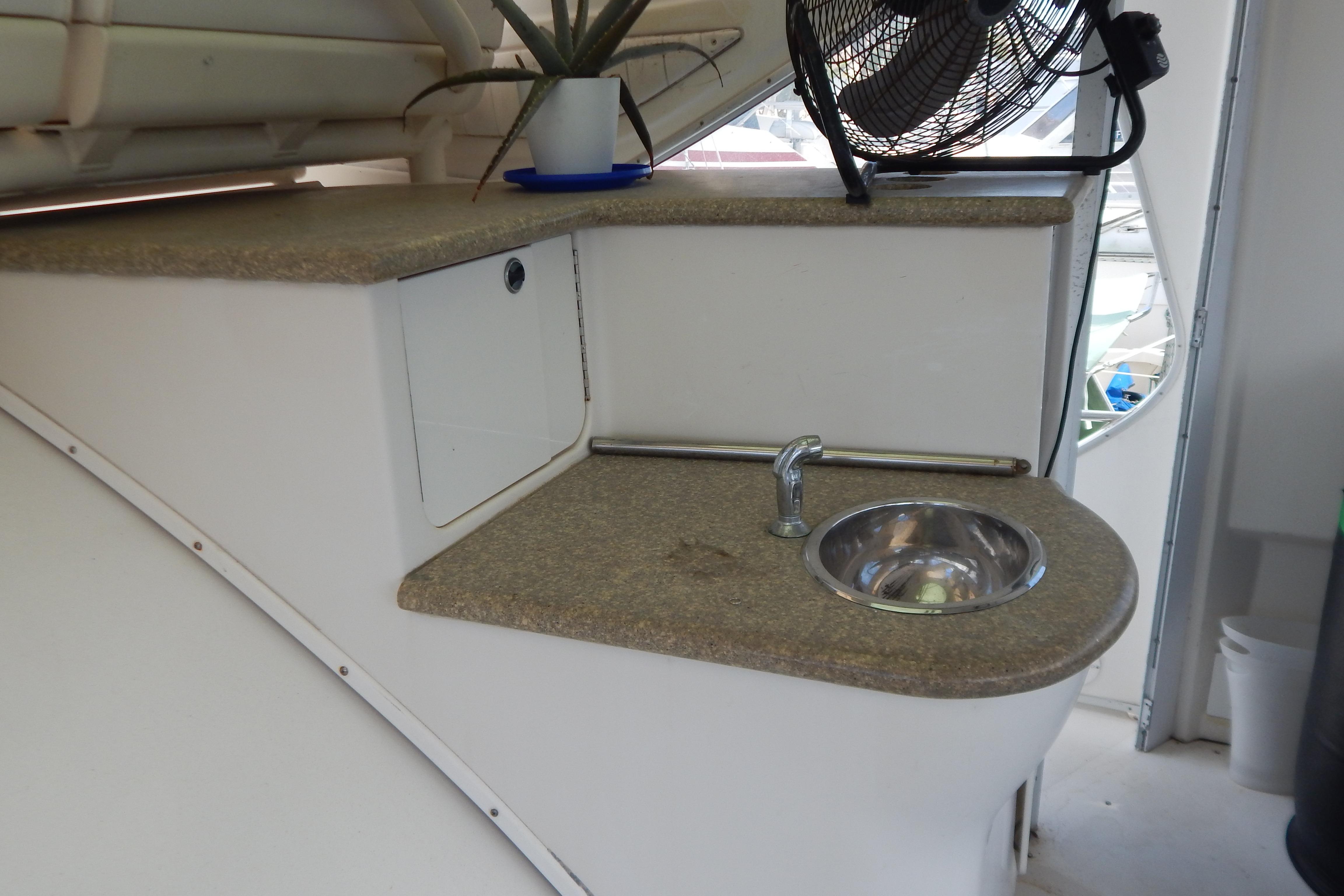 Compact kitchenette with sink and fan on a 1998 Magnum 4100 SCR boat.