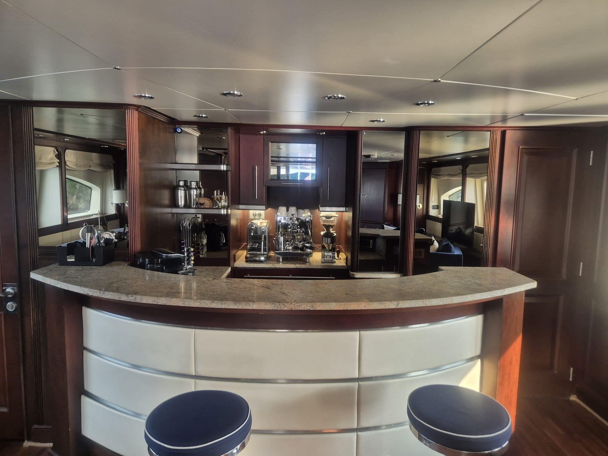 Luxurious interior of 2000 Benetti Classic 115 yacht with elegant bar and seating area.