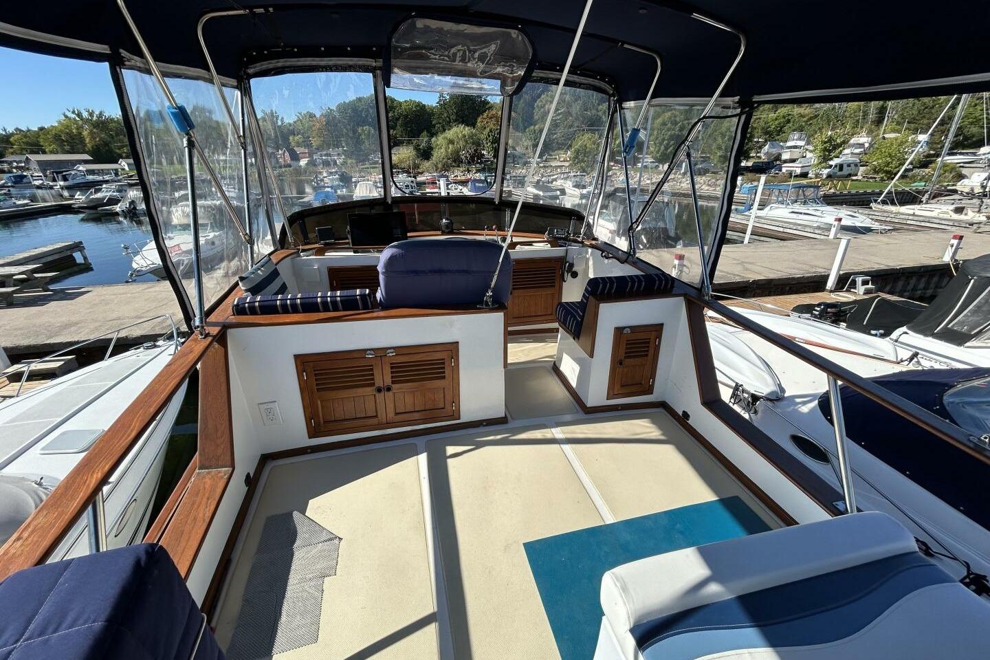 1987 Monk 36 yacht interior with seating, wood accents, and marina view.