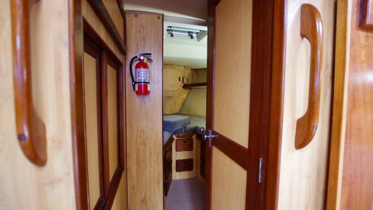 Interior of 1981 Morgan Out Island 41 sailboat with wooden finishes and fire extinguisher.