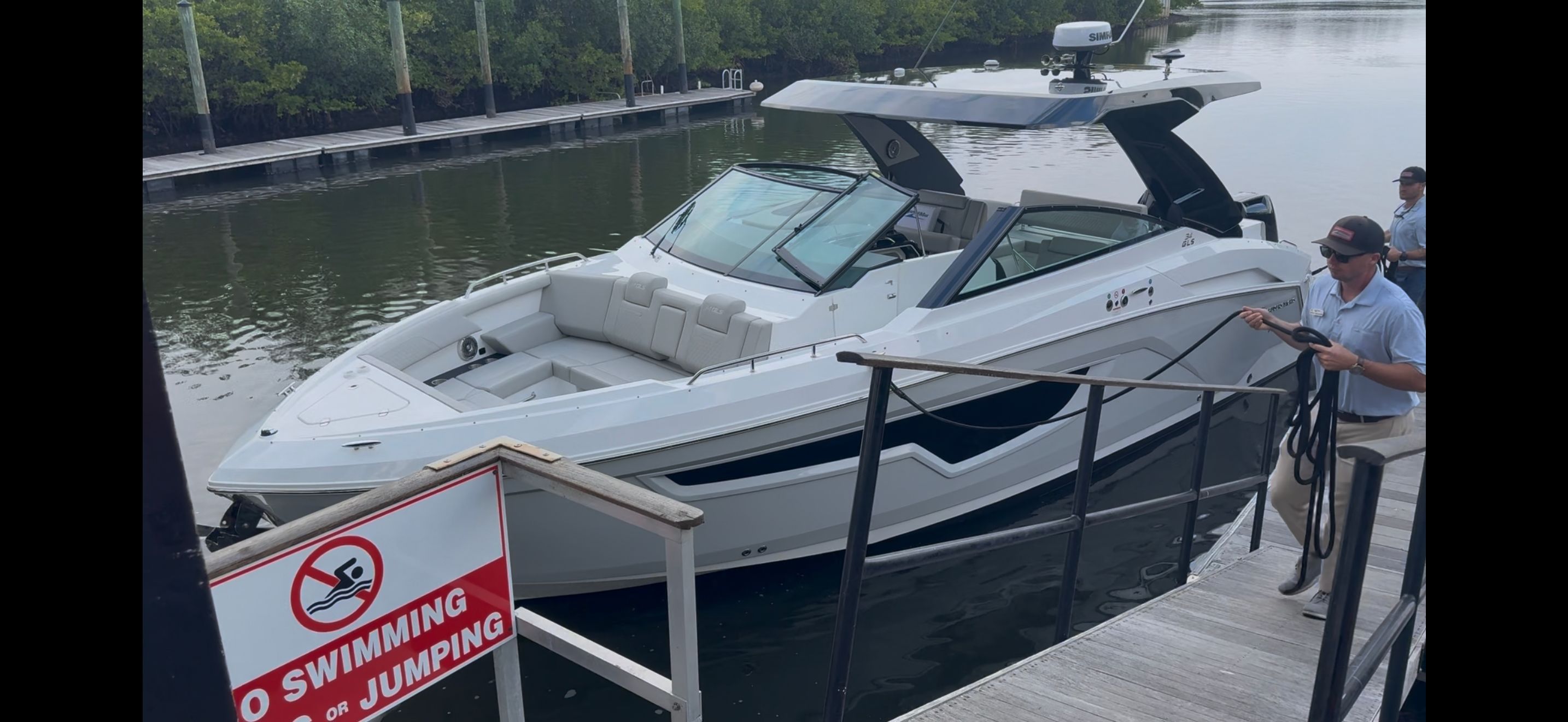 A modern 2025 Cruiser Yachts 34GLS is docked at a serene pier.