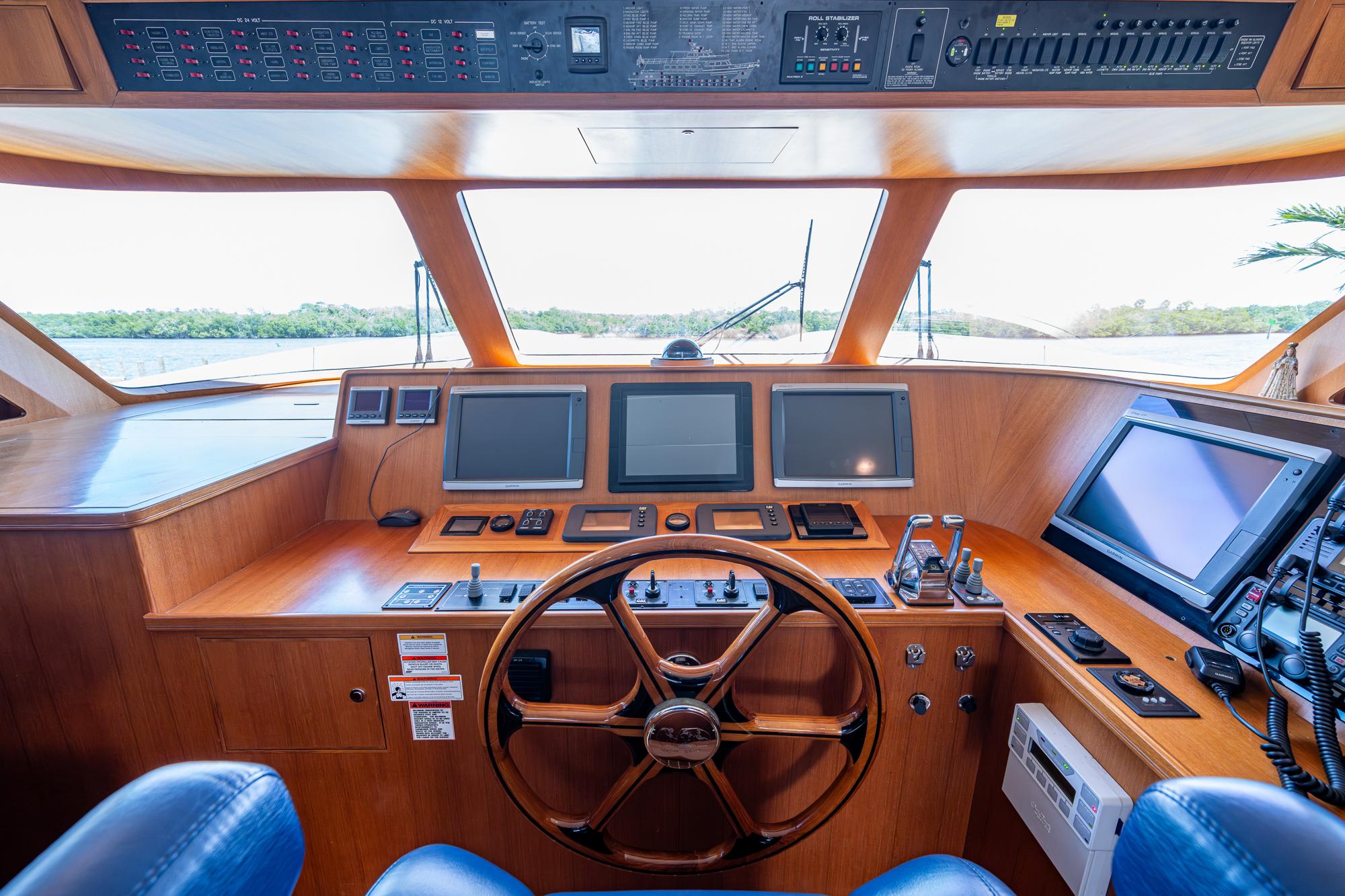 2013 Marlow Explorer Enclosed Bridge (CB) helm with advanced navigation systems and wooden steering wheel.