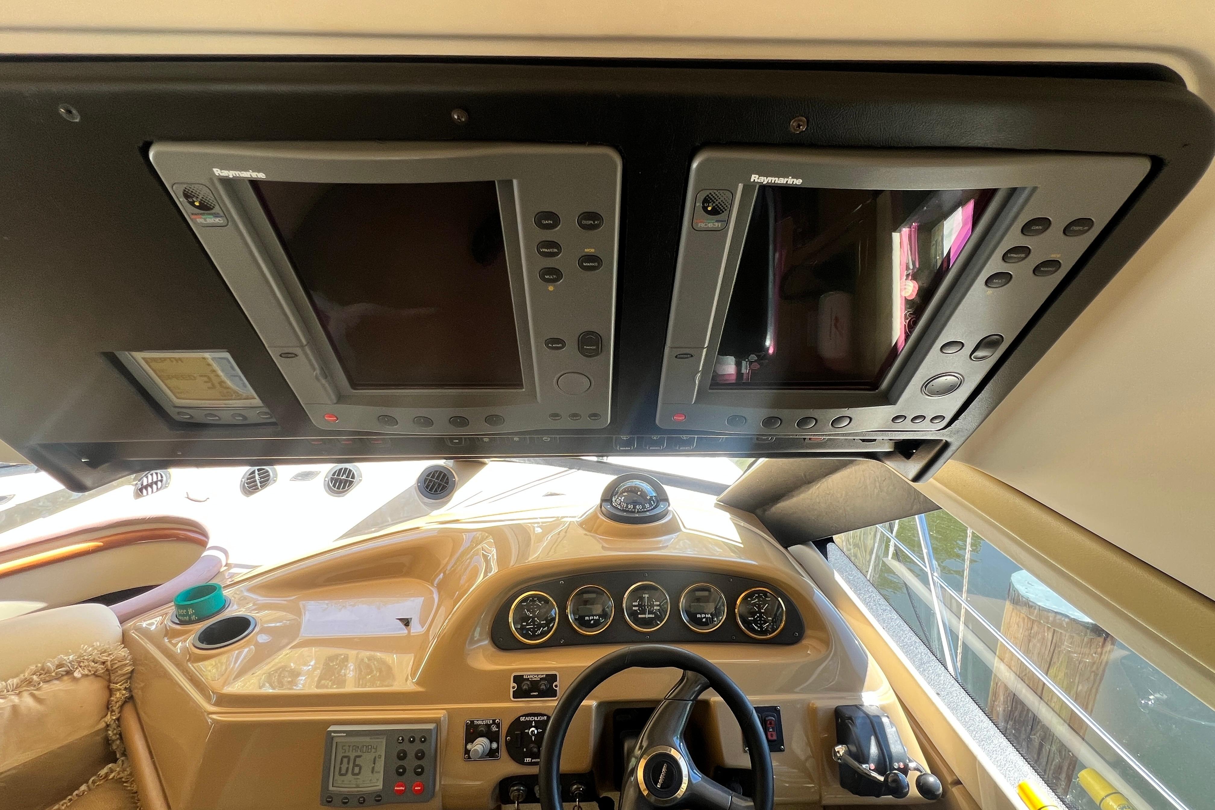 2003 Carver 450 Voyager Pilothouse helm with Raymarine navigation displays and control instruments.