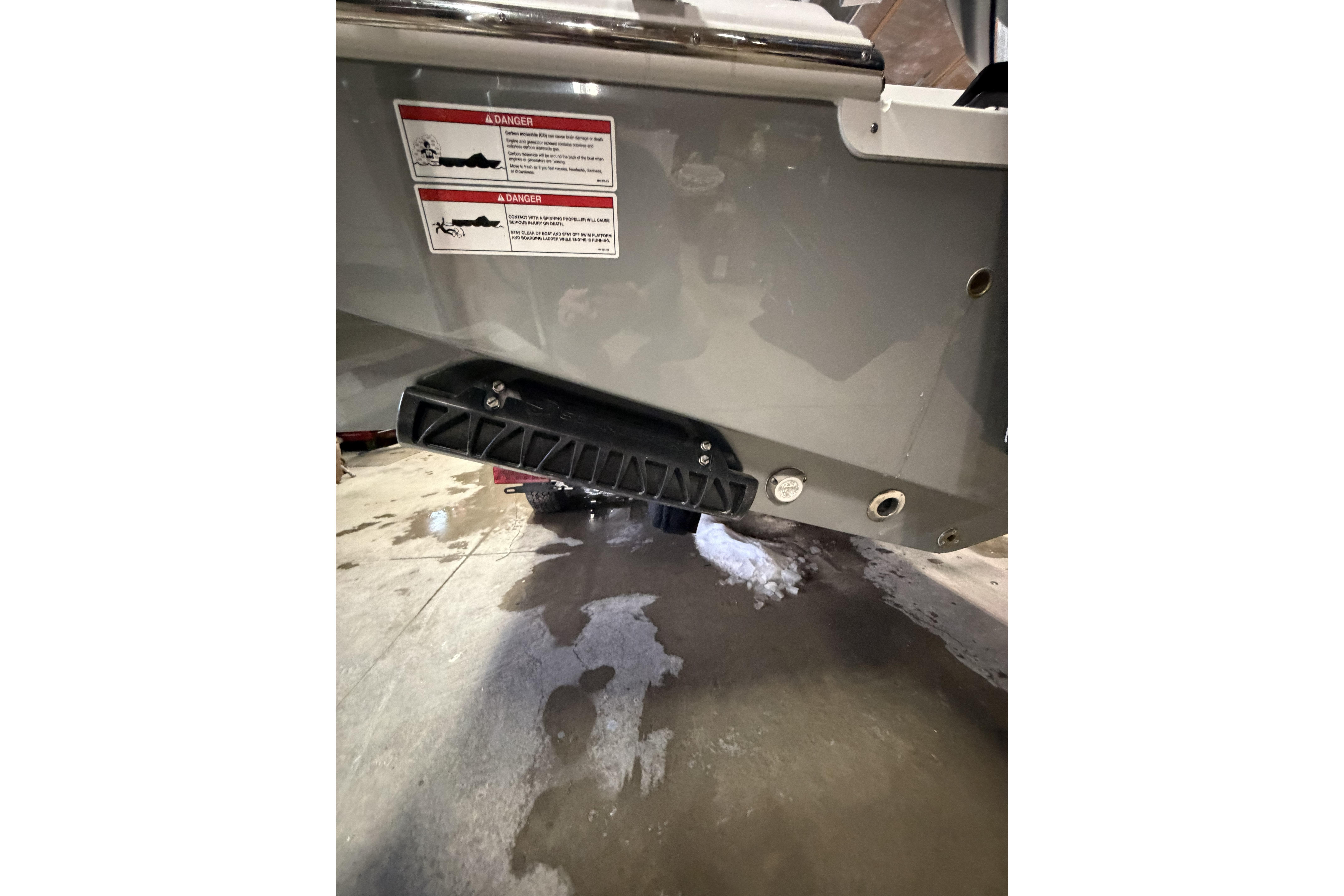 2026 Sportsman Open 232 Center Console boat hull with warning labels and drainage ports.