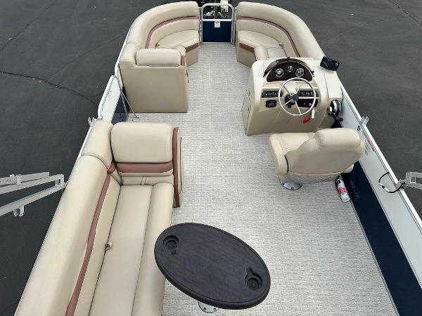 Interior view of a 2018 South Bay S224CR pontoon boat with beige seating and a table.