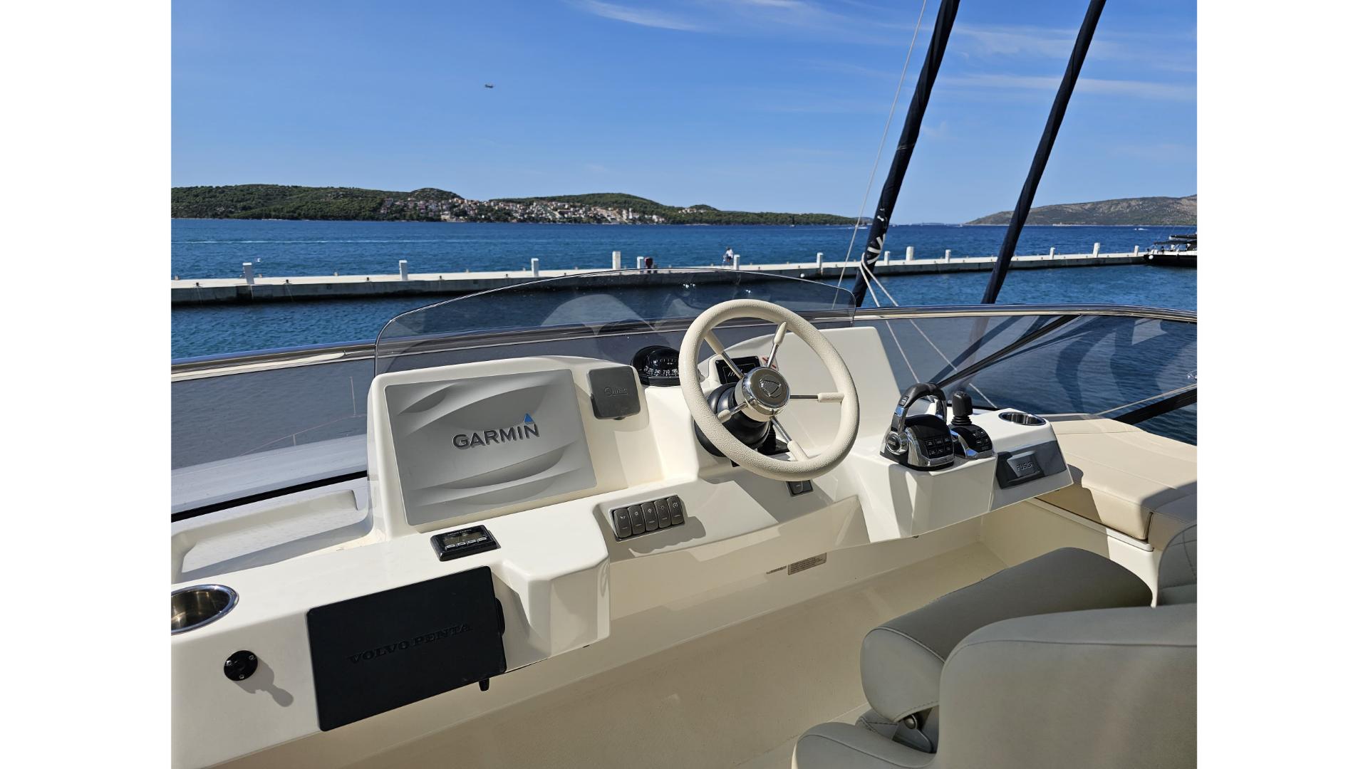 Cockpit of 2017 Absolute NAVETTA 58 yacht with Garmin navigation, overlooking serene waters.