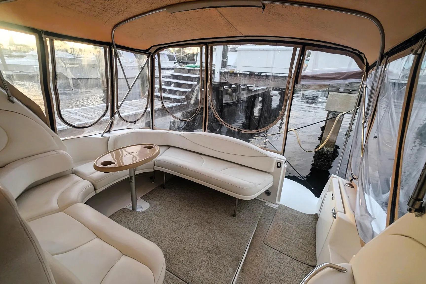 Interior of 2000 Sea Ray 380 Sundancer yacht with beige seating and table.