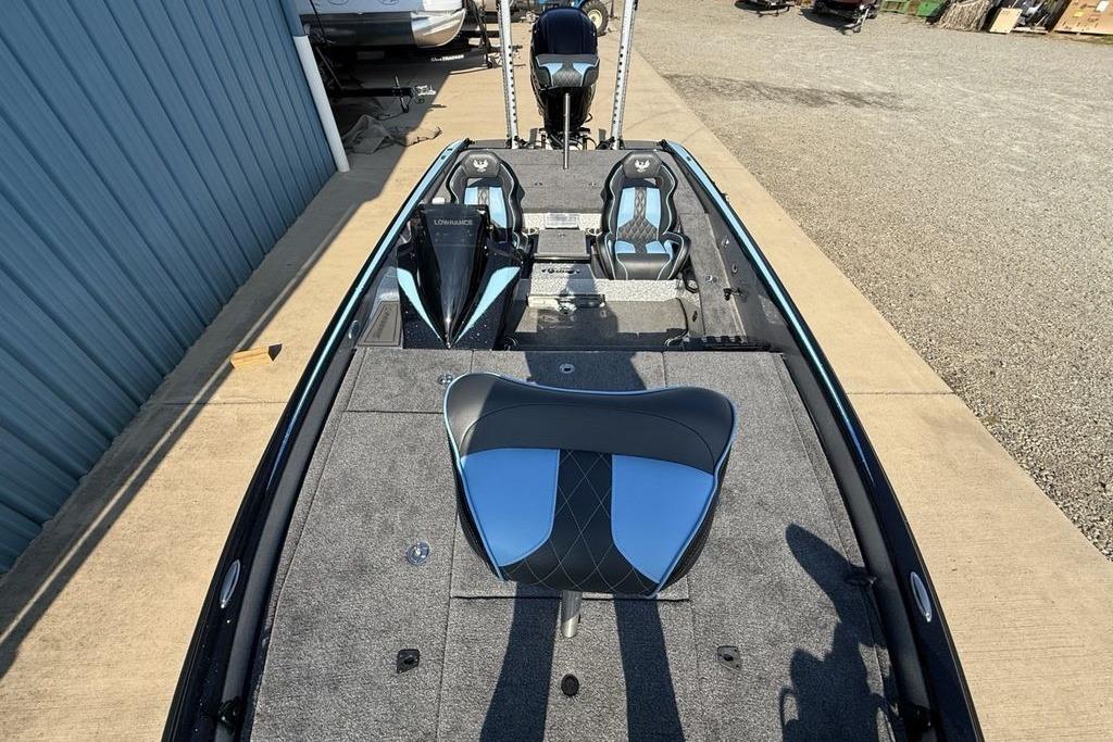 2026 Phoenix 20 XE boat interior with blue and black seating, parked outdoors.