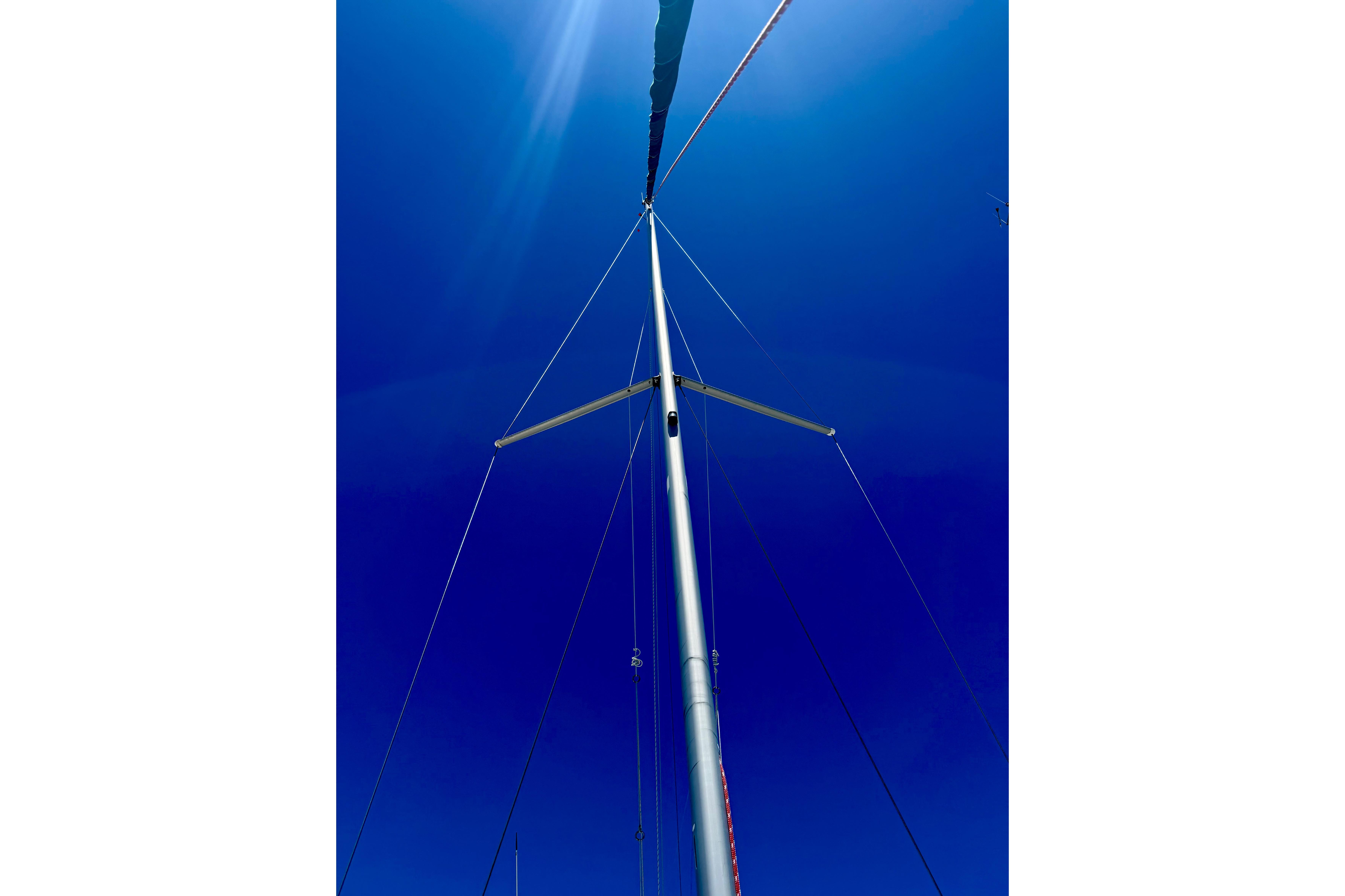 Mast of 2002 Beneteau Oceanis Clipper 311 sailboat against clear blue sky.