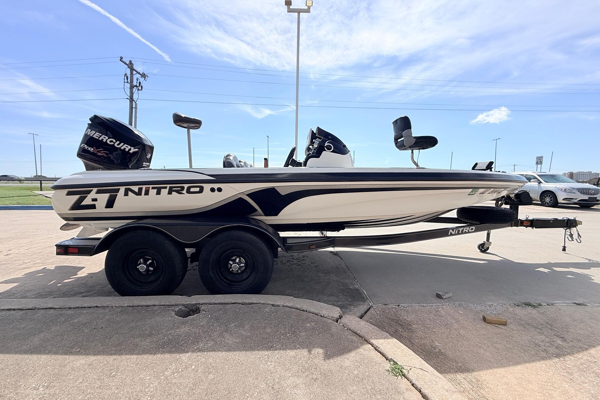 2011 Nitro Z-7 boat with Mercury engine on trailer, parked outdoors.